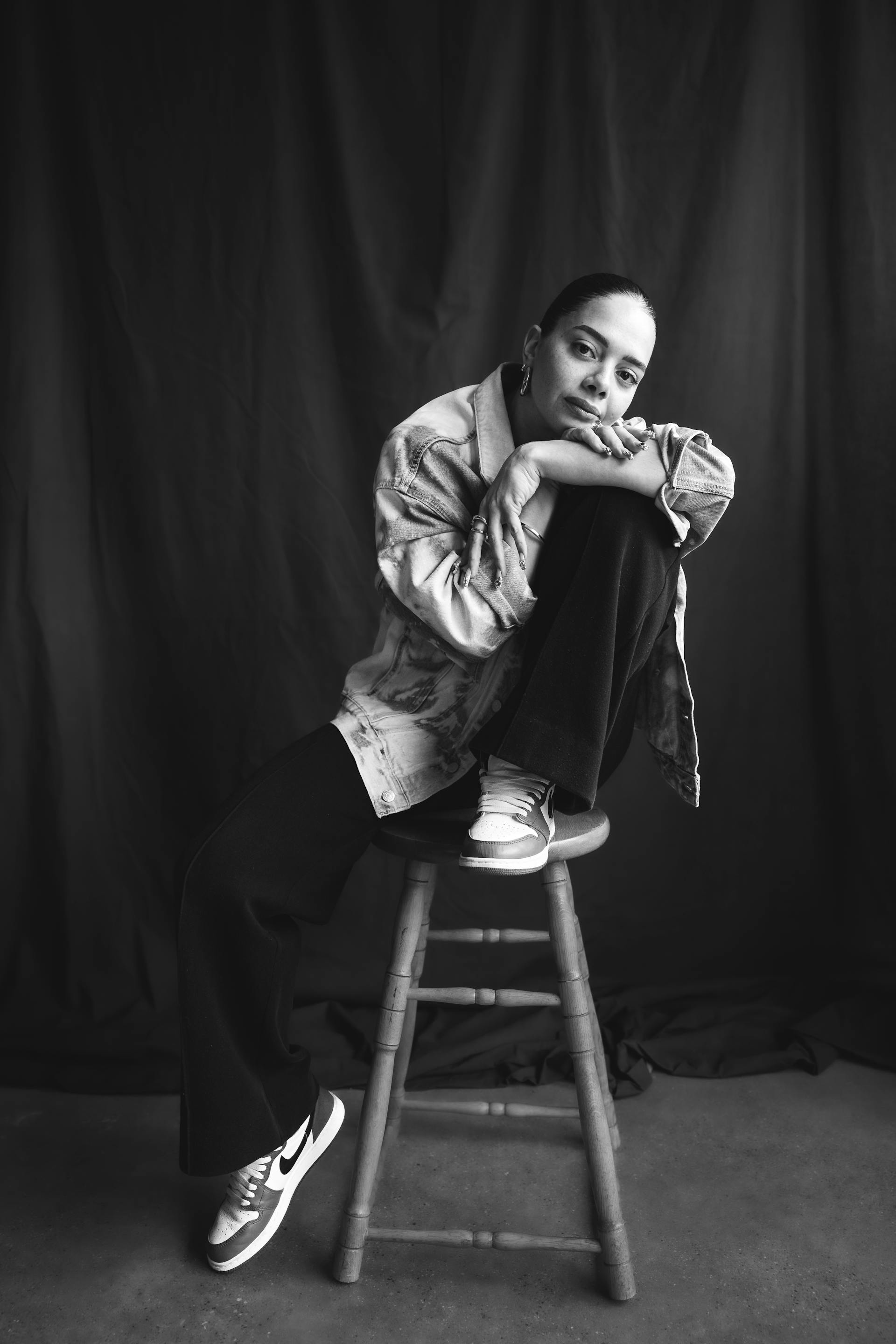 A woman pausing while seated on a wooden stool