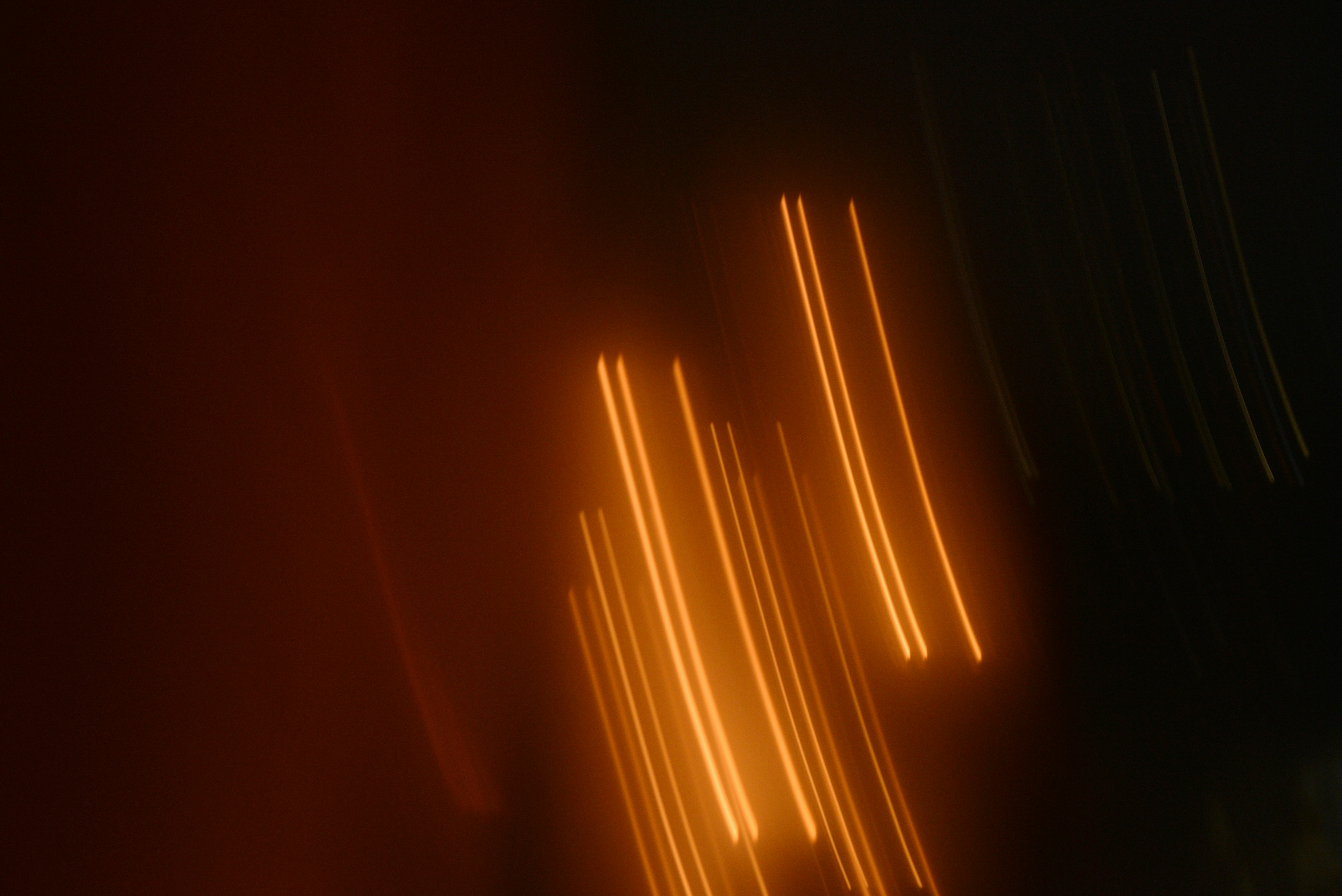 Blurry orange lights streak across a dark background