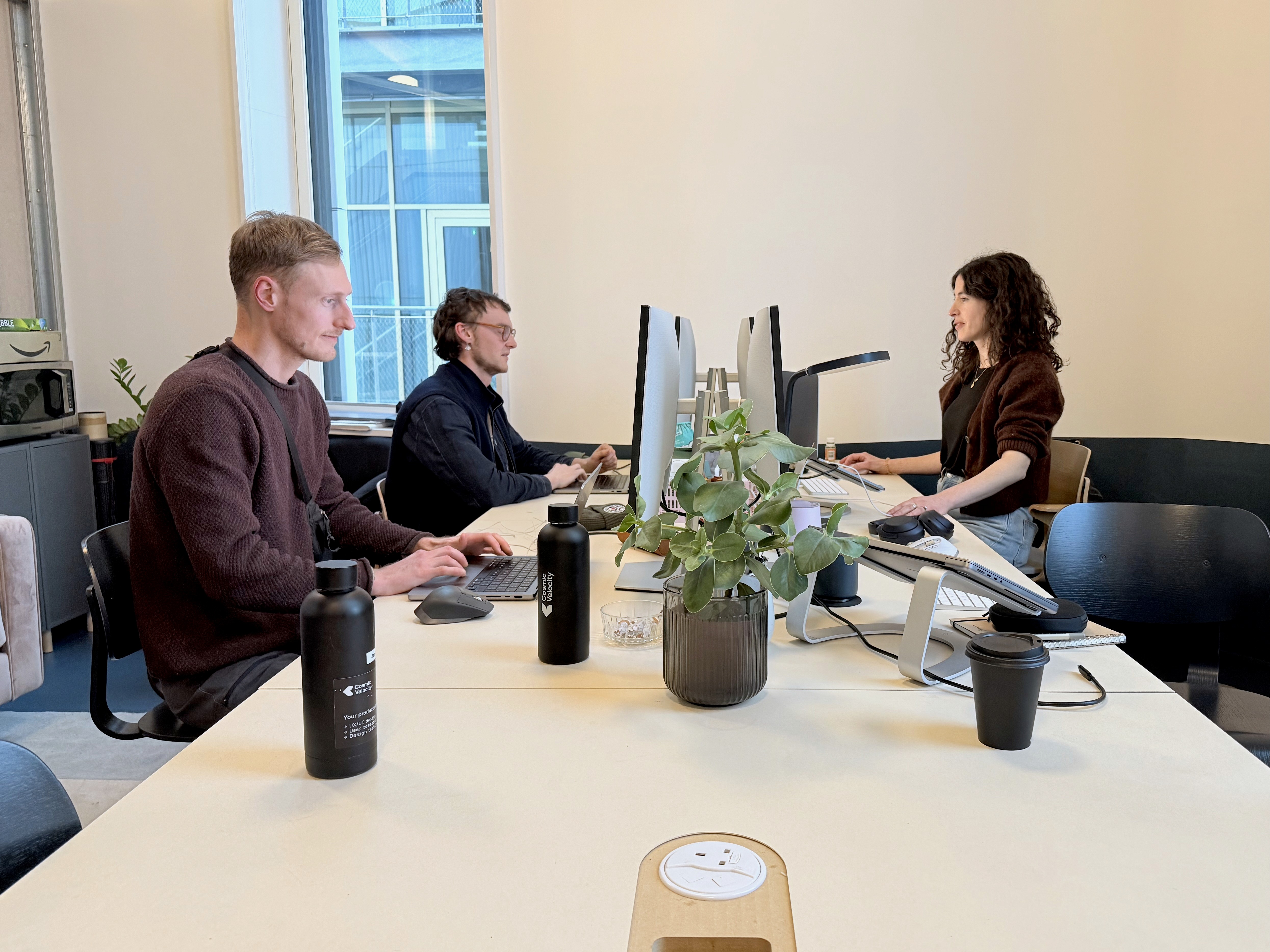 Three designers working at their desks at the Cosmic Velocity office in Greenwich