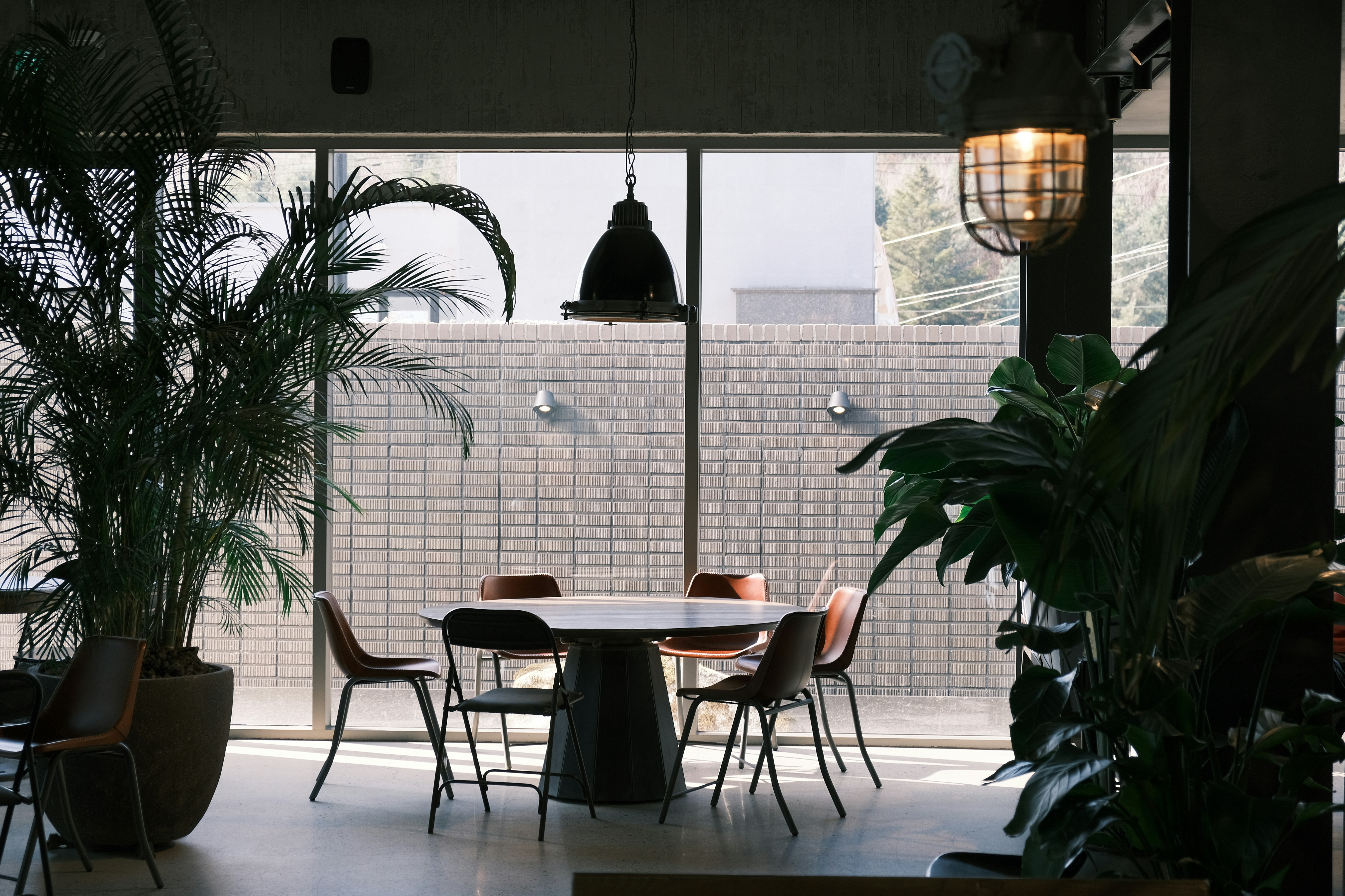 a table and chairs in a room with large windows