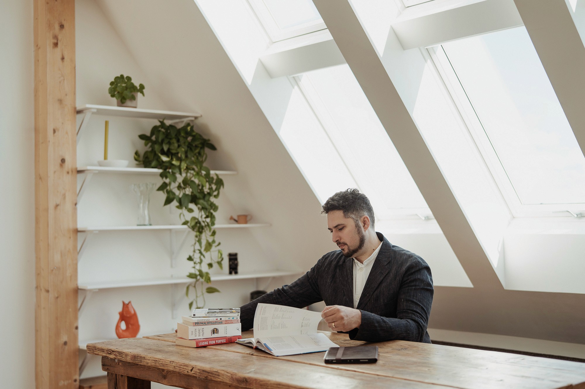 StoryOS founder reviewing strategy and branding research materials in a light-filled workspace