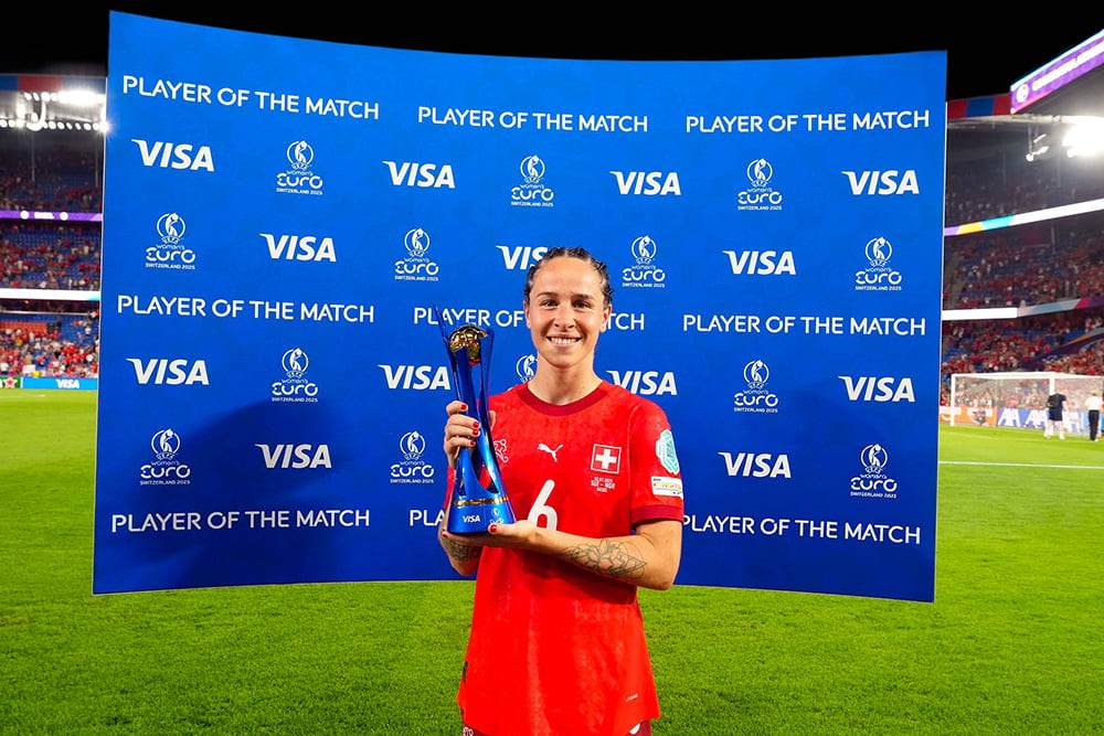 Sponsor markalarıyla desteklenen ödül töreninde kupasını tutan profesyonel futbolcu