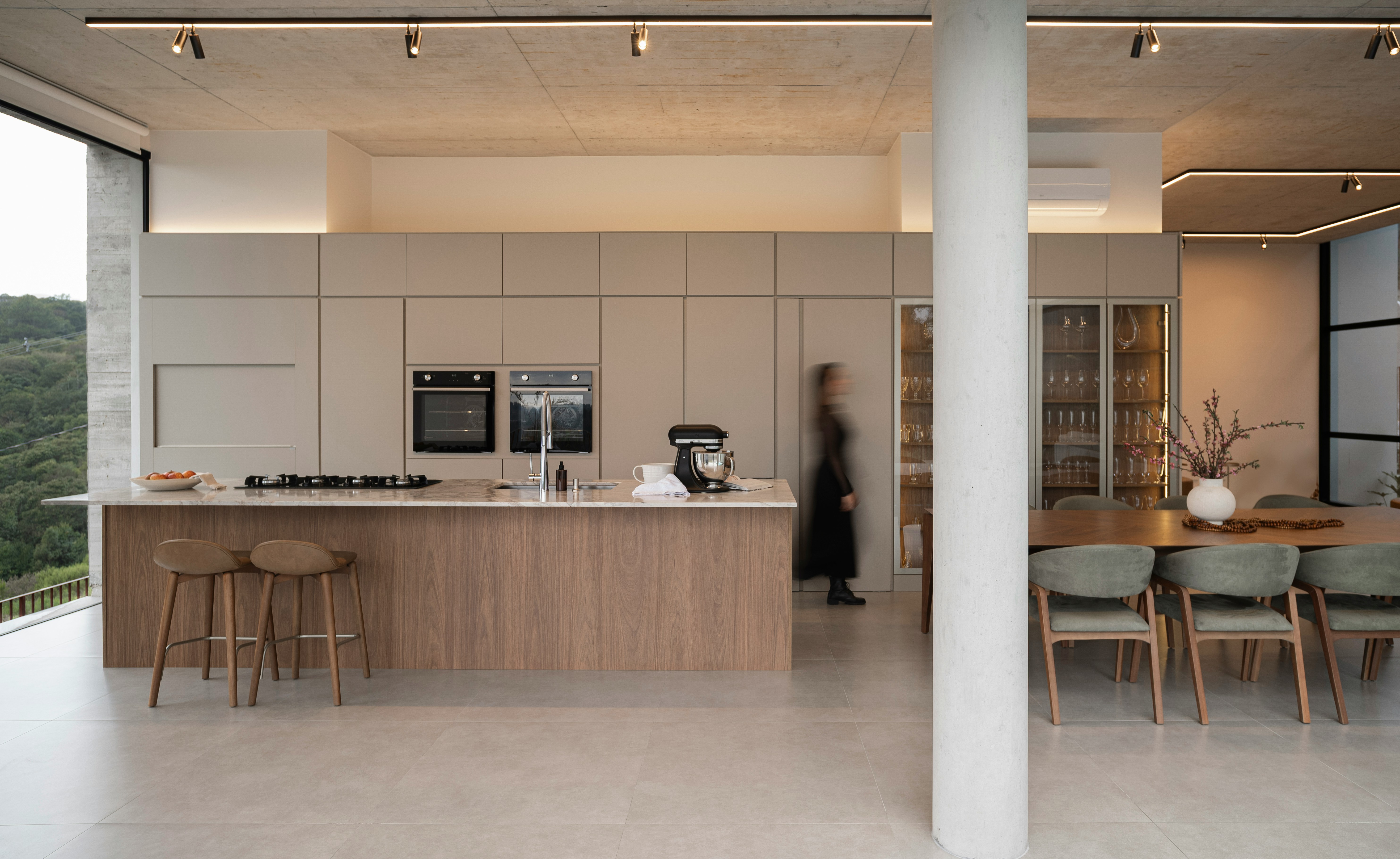 Modern kitchen and dining area with large windows.