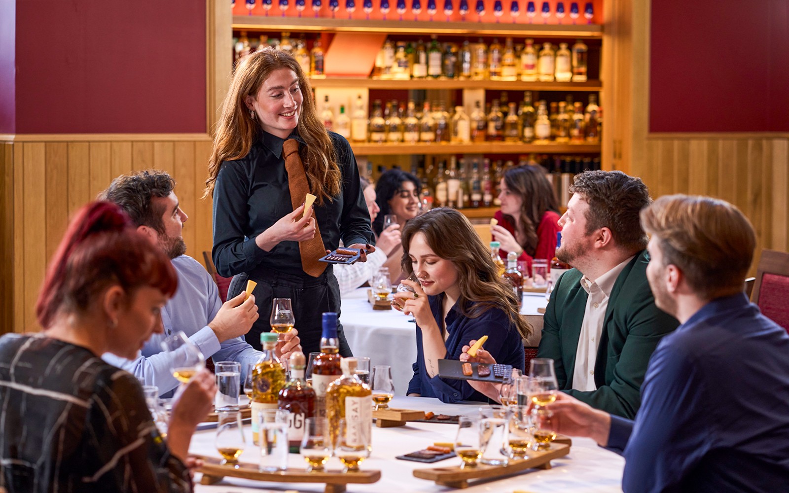 Guests learning about Scotch whisky with a host at the Scotch Whisky Experience in Edinburgh, Scotland.