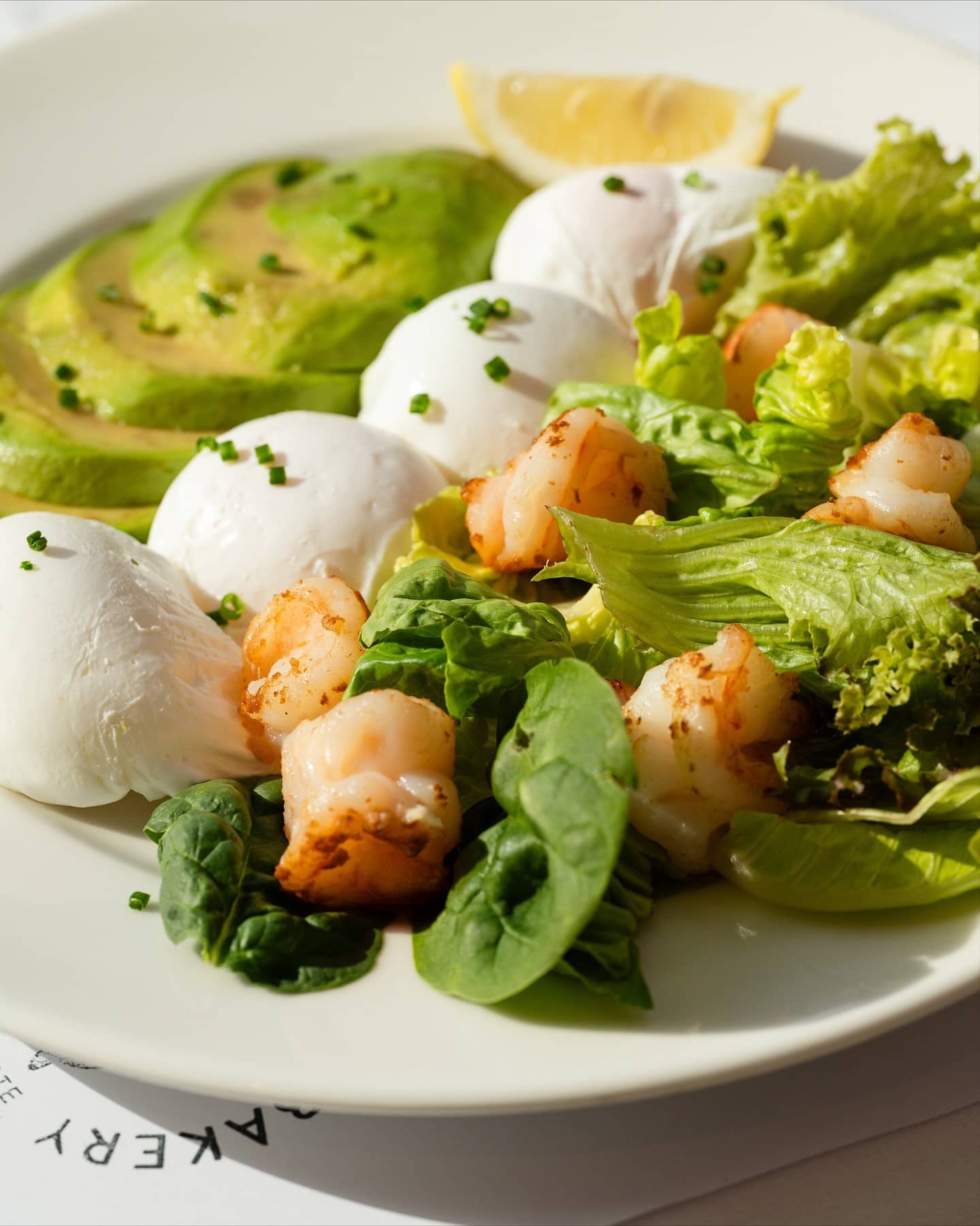 Healthy grilled shrimp, avocado, and poached egg plate at Mandy's Bakery, perfect for weekend breakfast Dubai food hall dining.
