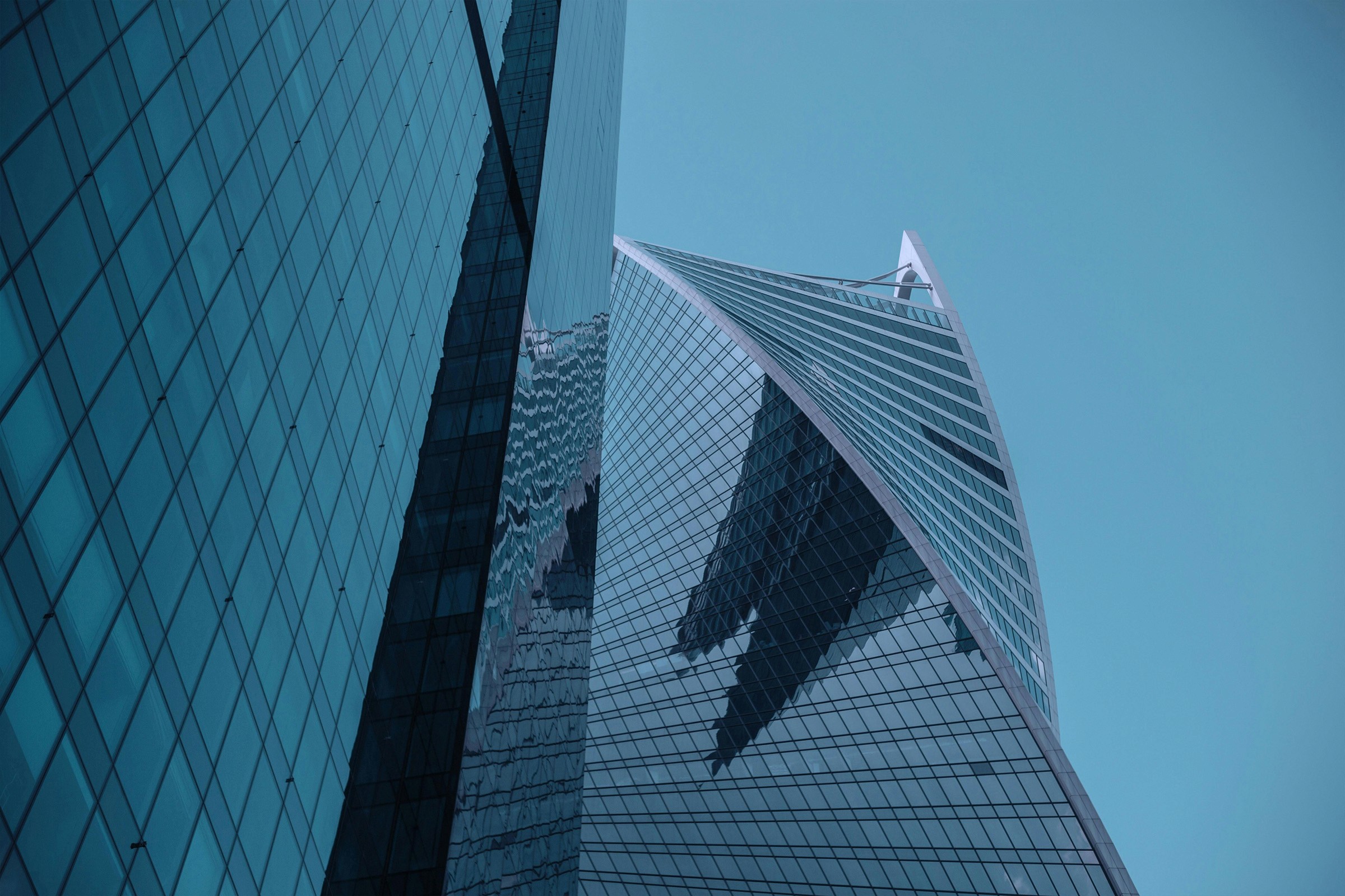 Striking modern skyscraper with a glass exterior, reflecting the cityscape and sky