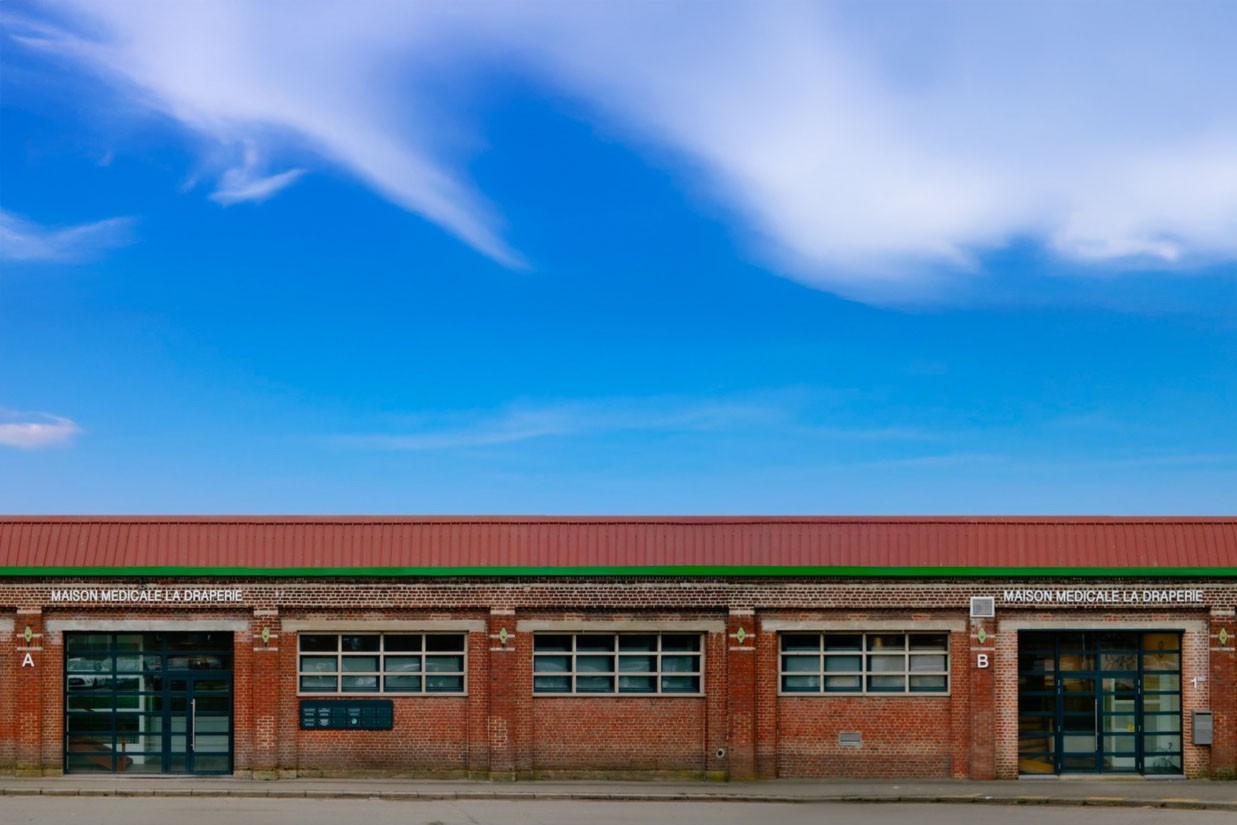 woman in blue tank top standing beside white wall