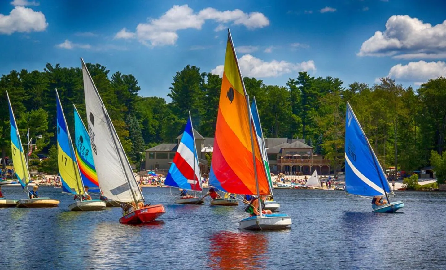 Rainbow-sailed sailboats racing on Lake Naomi in summer, Pocono Pines, PA