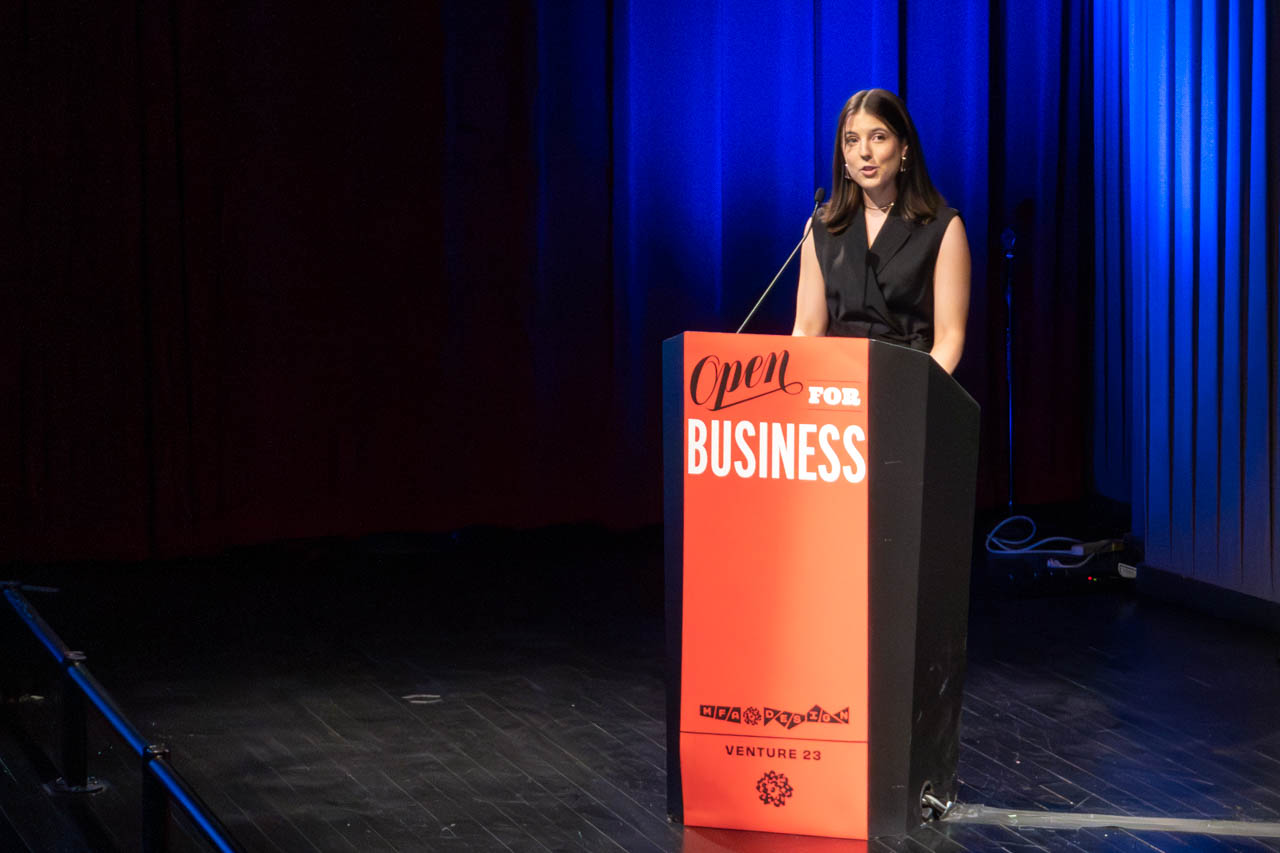 woman standing at a podium delivering a presentation