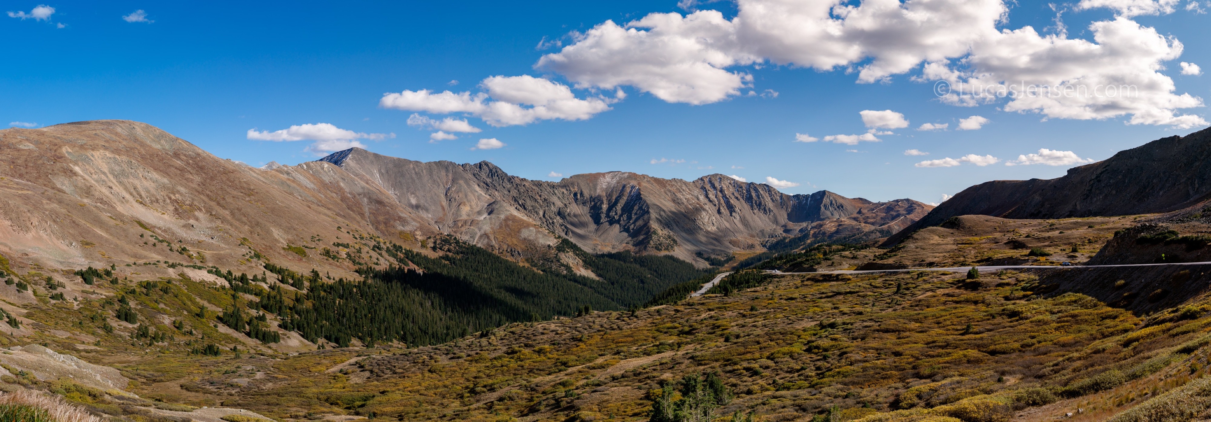 Panoramic landscape photograph of mountains, water, desert, or coast by Lucas Jensen