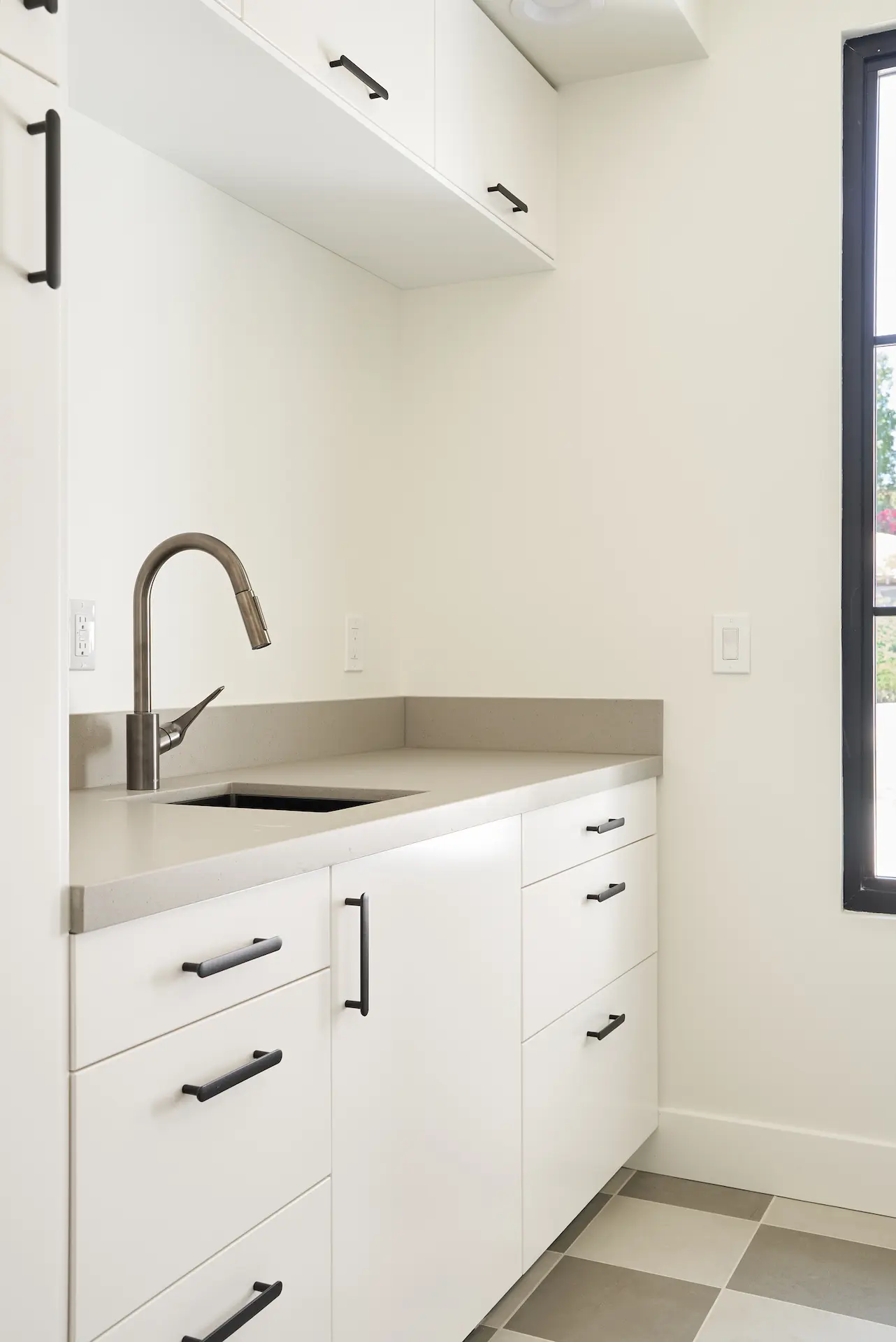 View of the laundry room, focussing on the sink area and surrounding cabinetry. Photo by Todd Huge.