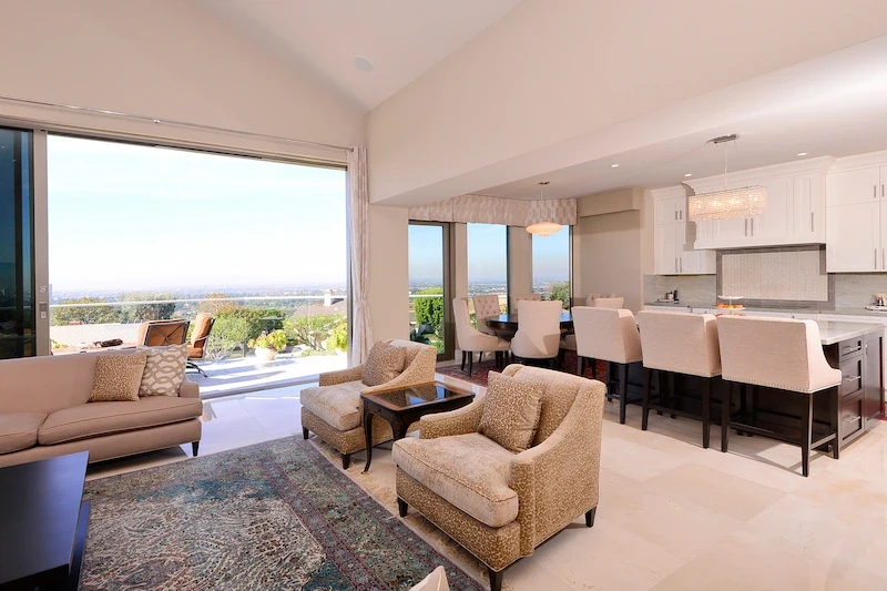 Open-concept layout with living area and kitchen, cityscape backdrop in Harbor Ridge Transitional Remodel.