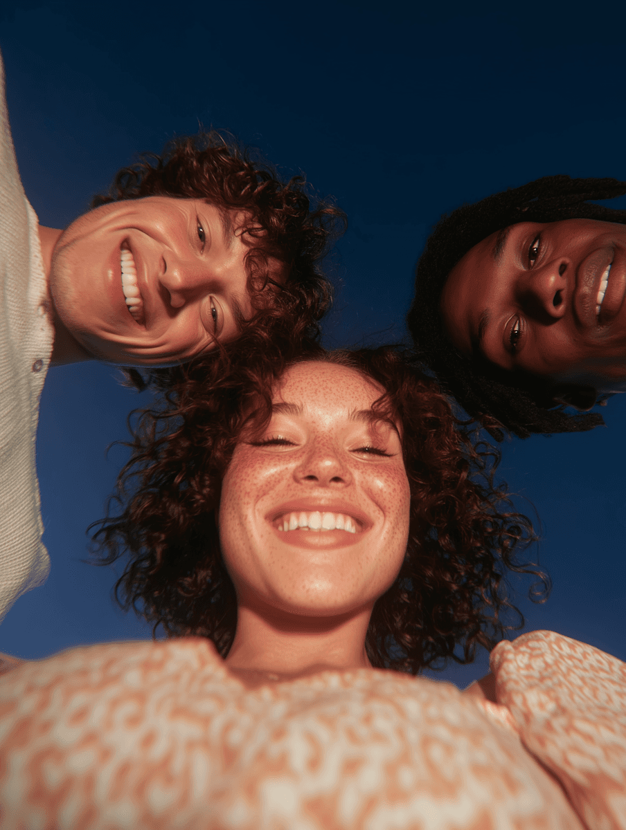 Three young people looking into a camera.