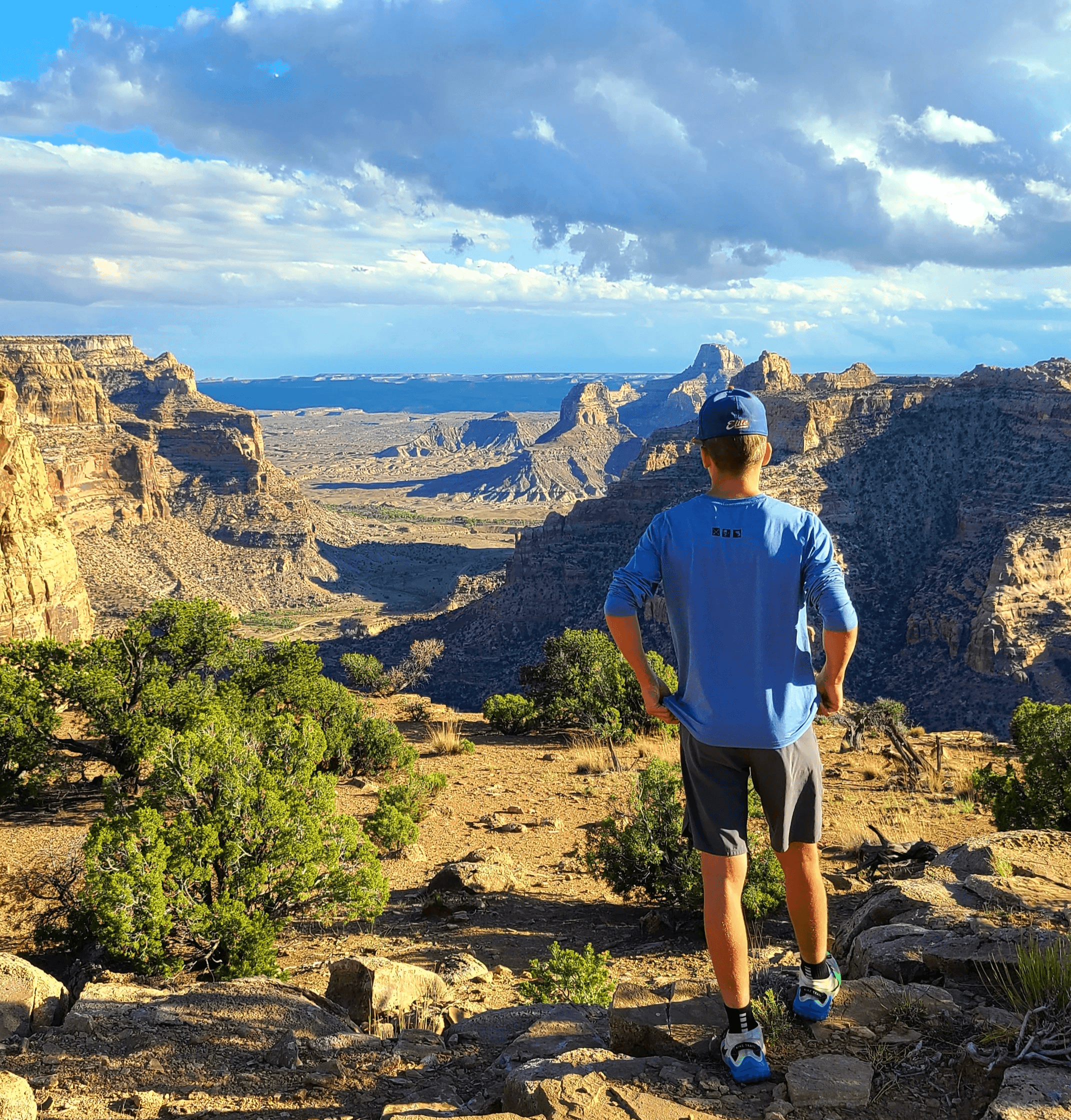 Boy camping looking over a desert landscape