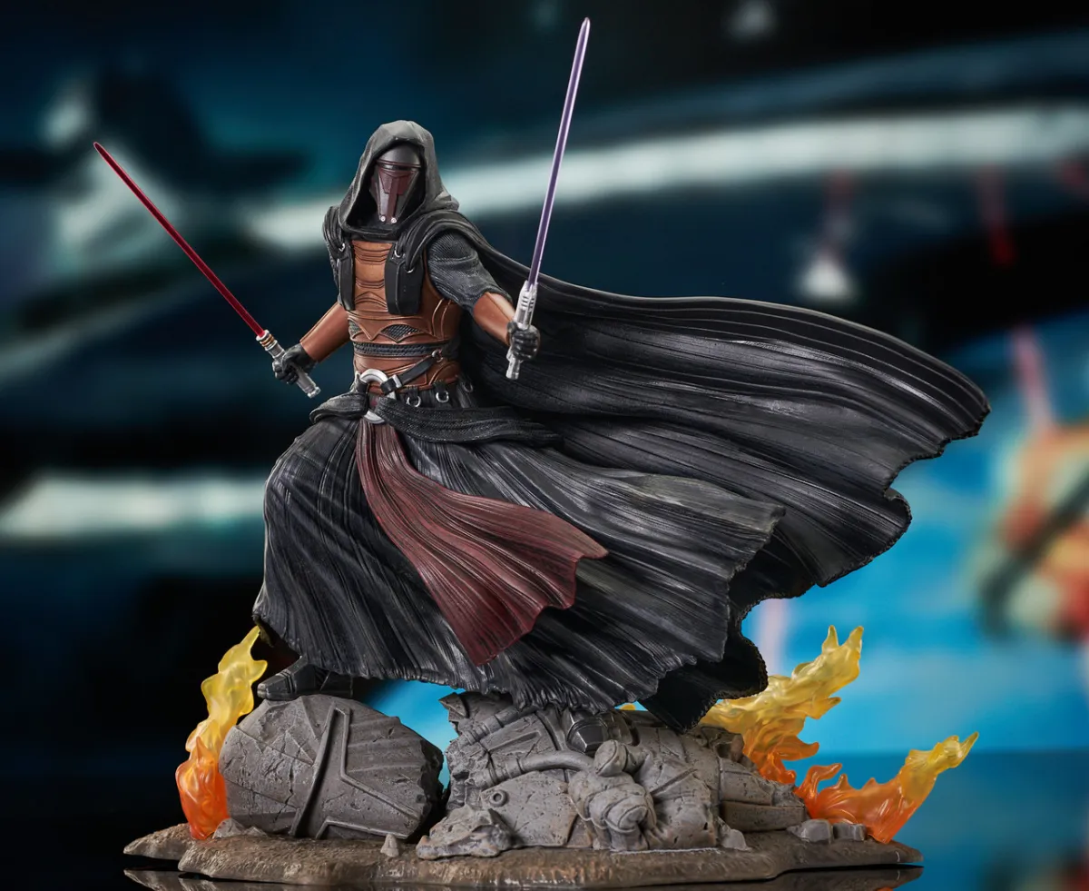 Gentle Giants Statue of Darth Revan holding both his red and purple lightsabers. He has a Mandalorian mask and black robest and in standing on a burning statue