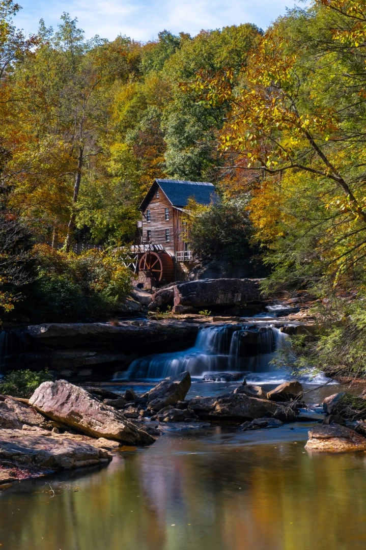 A small wooden building sitting on top of a river, WV.