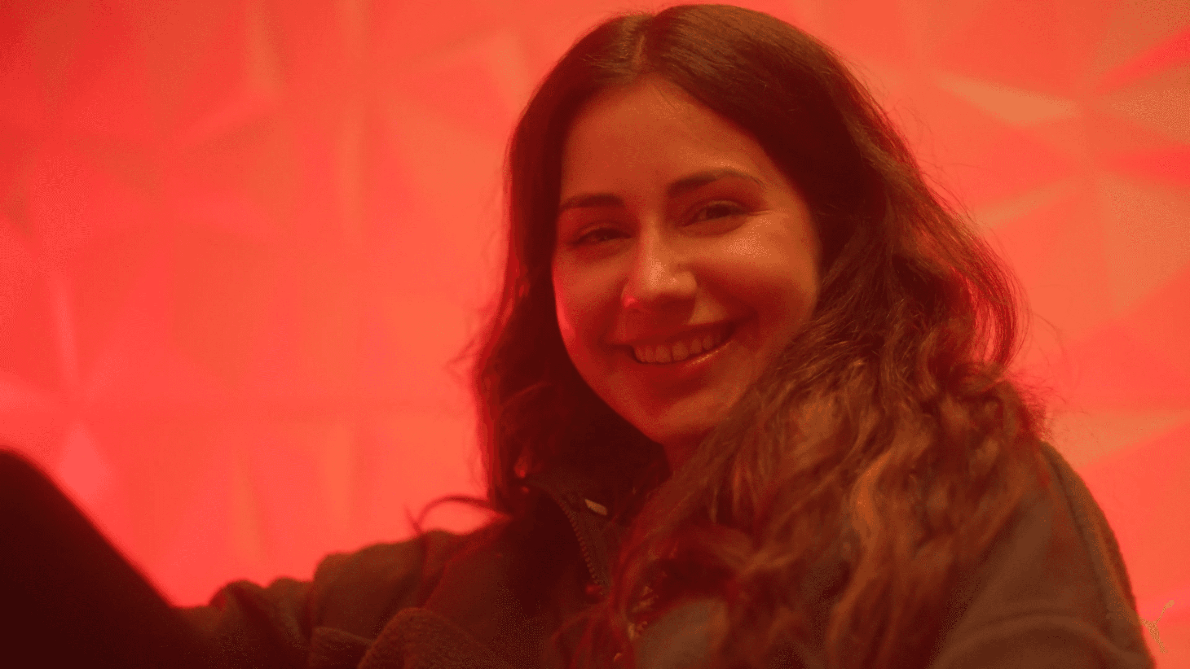 GuhRL smiles in red light during the PUMA She Moves Us shoot