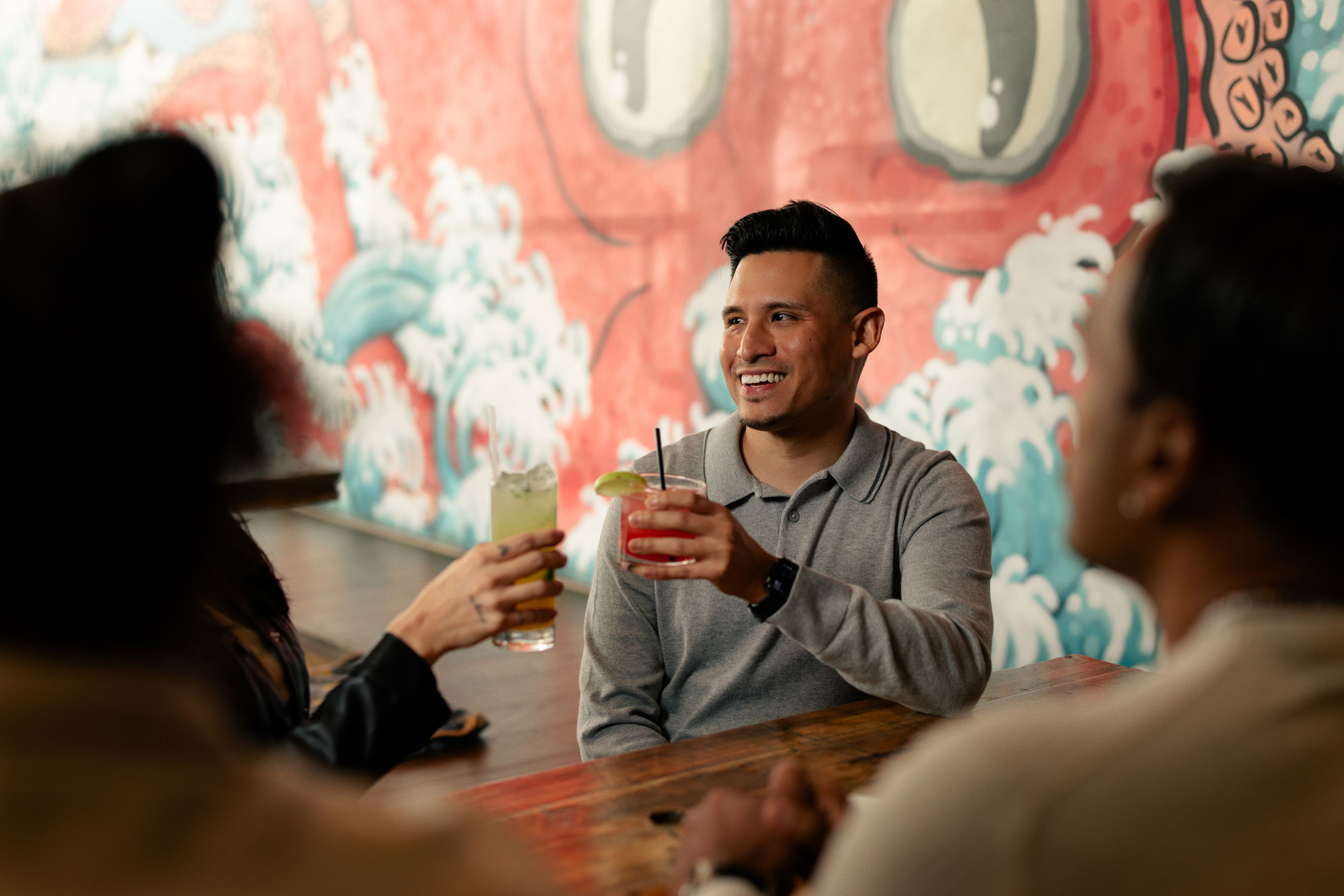 Friends having cocktails at sushi restaurant.