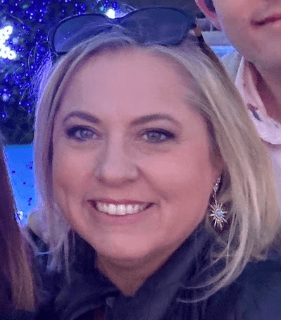 woman staring directly at camera near pink wall