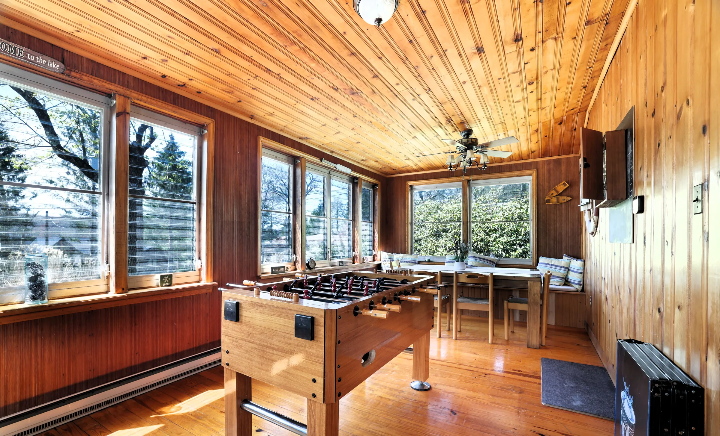 Pine-paneled sunroom with foosball table, wood ceiling and bar seating at DeerPath Crossing