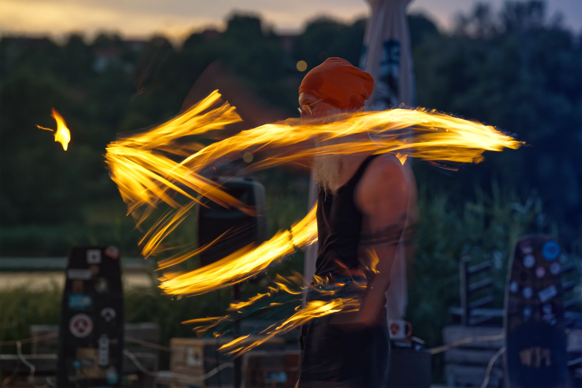 Flammenartist Eberhard Wolter erzeugt bei einer Feuerperformance am Brombachsee dynamische Lichtspuren in der Abenddämmerung.