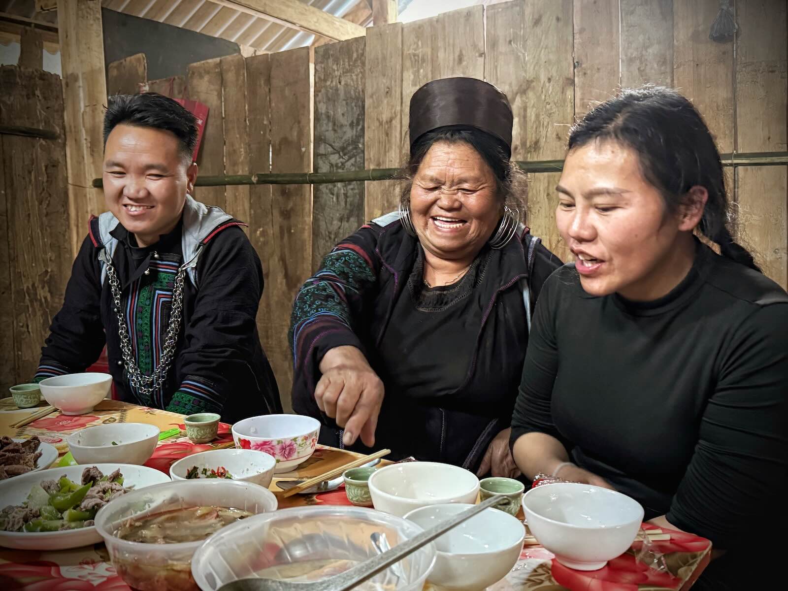 Black Hmong family sharing dinner in a homestay during a trekking experience in Sapa