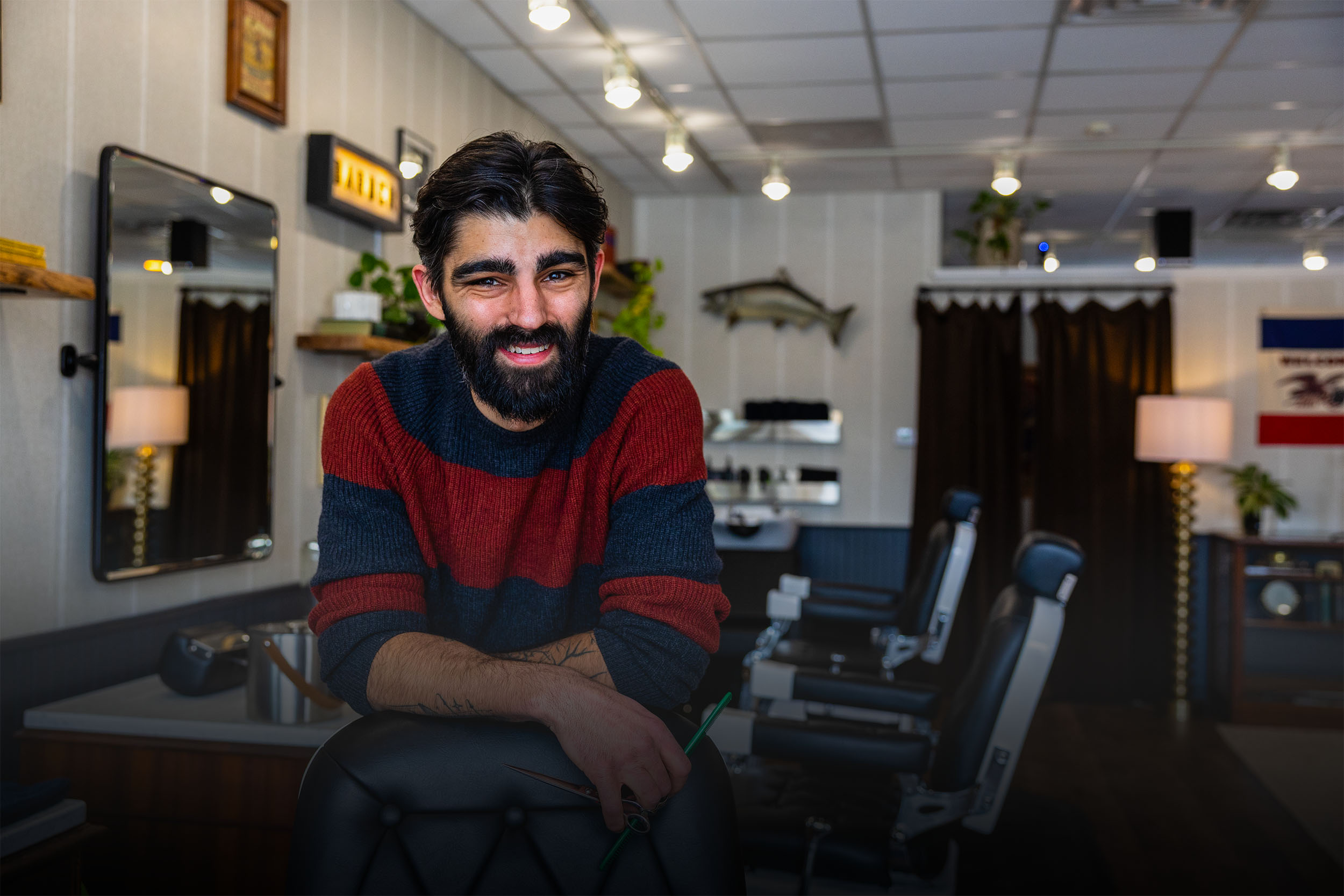Portrait of Adam Calderone, barber and owner of Calderone’s Barbershop, inside the shop workspace