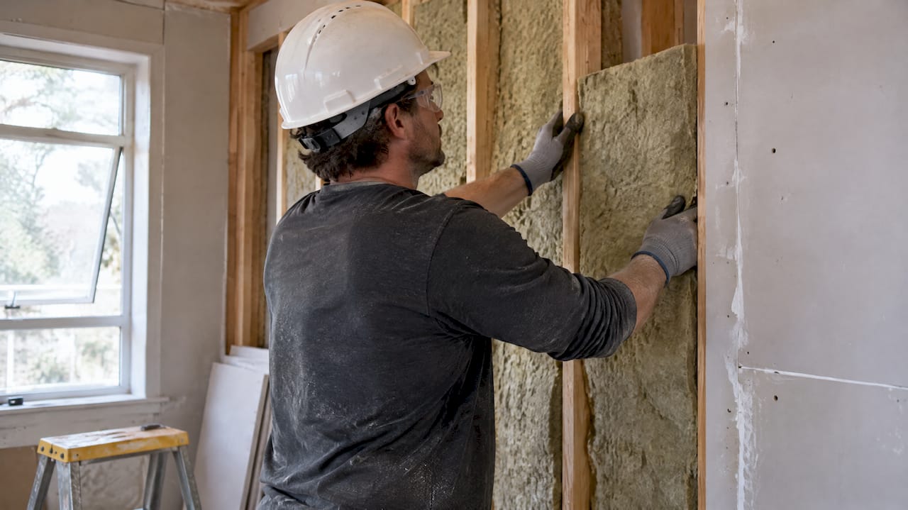 Worker fitting insulation with protective gear