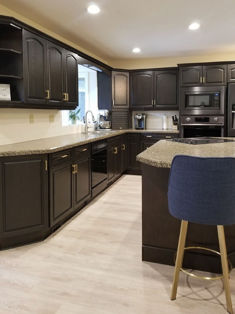 Image of Luxury kitchen design by KHD Homes featuring dark cabinetry, granite countertops, and modern appliances layout.
