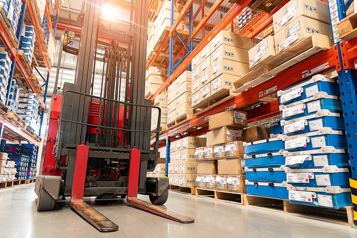 Manufacturing warehouse with stacked inventory and forklift - Fiscal 12 serves discrete and process manufacturers from $3M to $75M