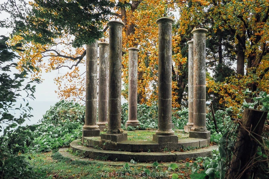 Stone colonnade among autumn trees
