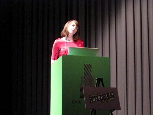 a young girl student in a red dress giving a speech on the stand