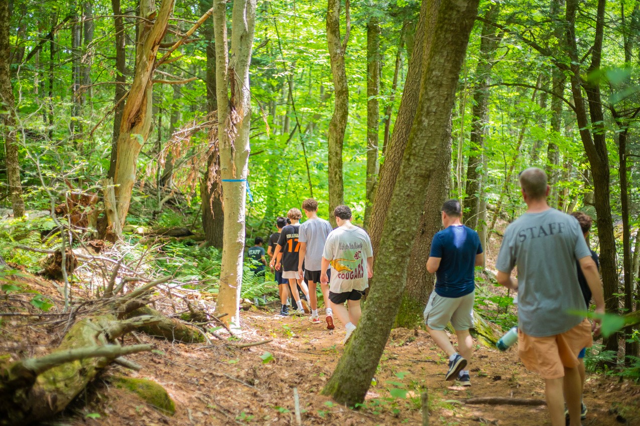 Campers hiking a wooded trail on the Camp Lenox property