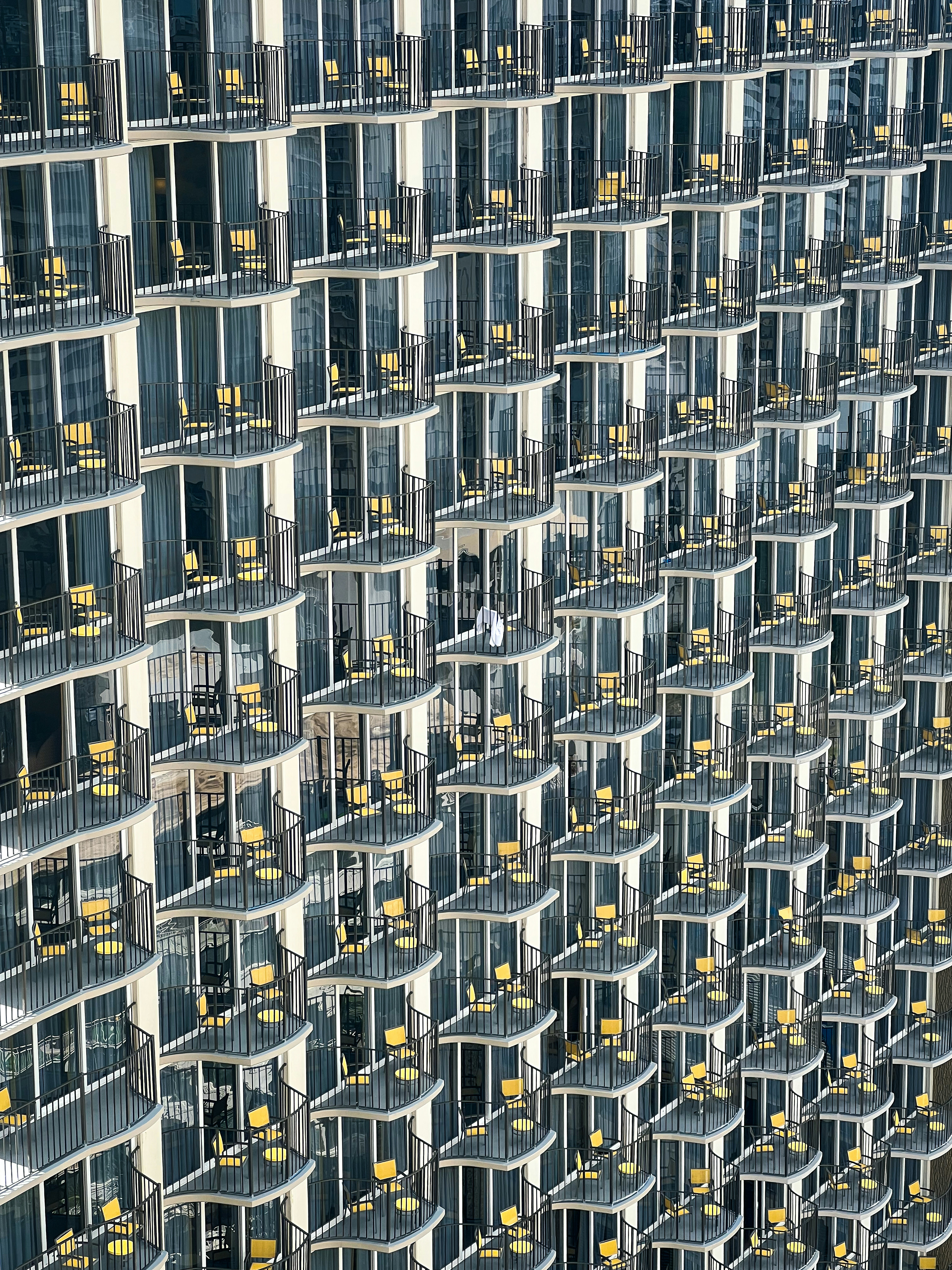 Man sits alone on a balcony of a modern building