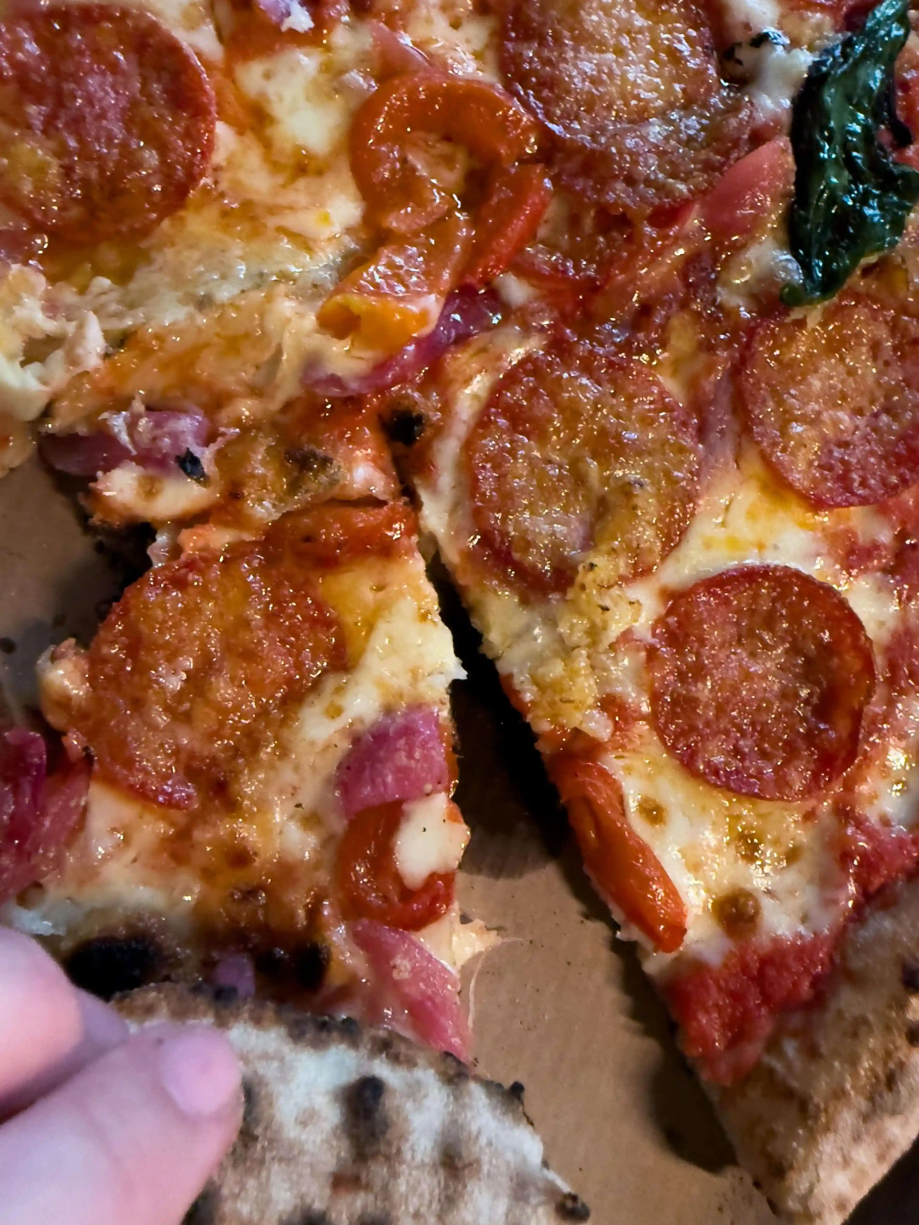 Freshly baked pizza topped with cheese, tomato, and fresh ingredients.