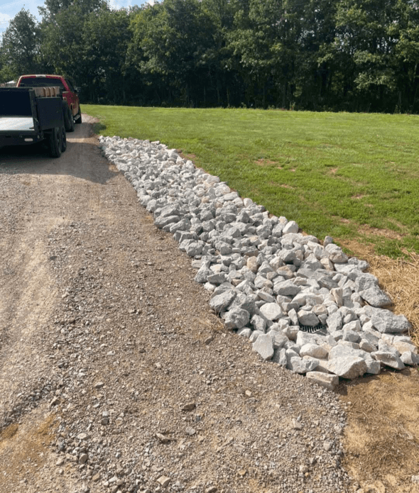 gray asphalt road between green grass field during daytime