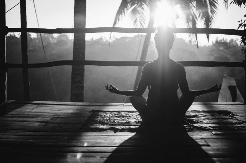 woman doing yoga meditation on brown parquet flooring