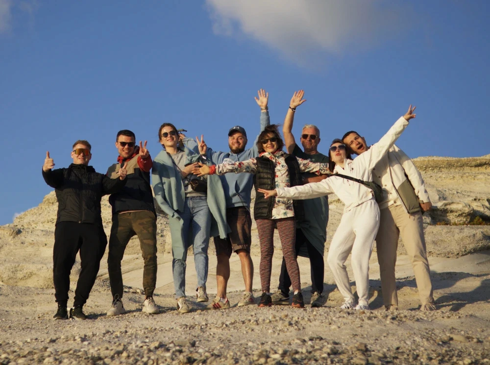 Group of happy people taking a photo in a sandy area