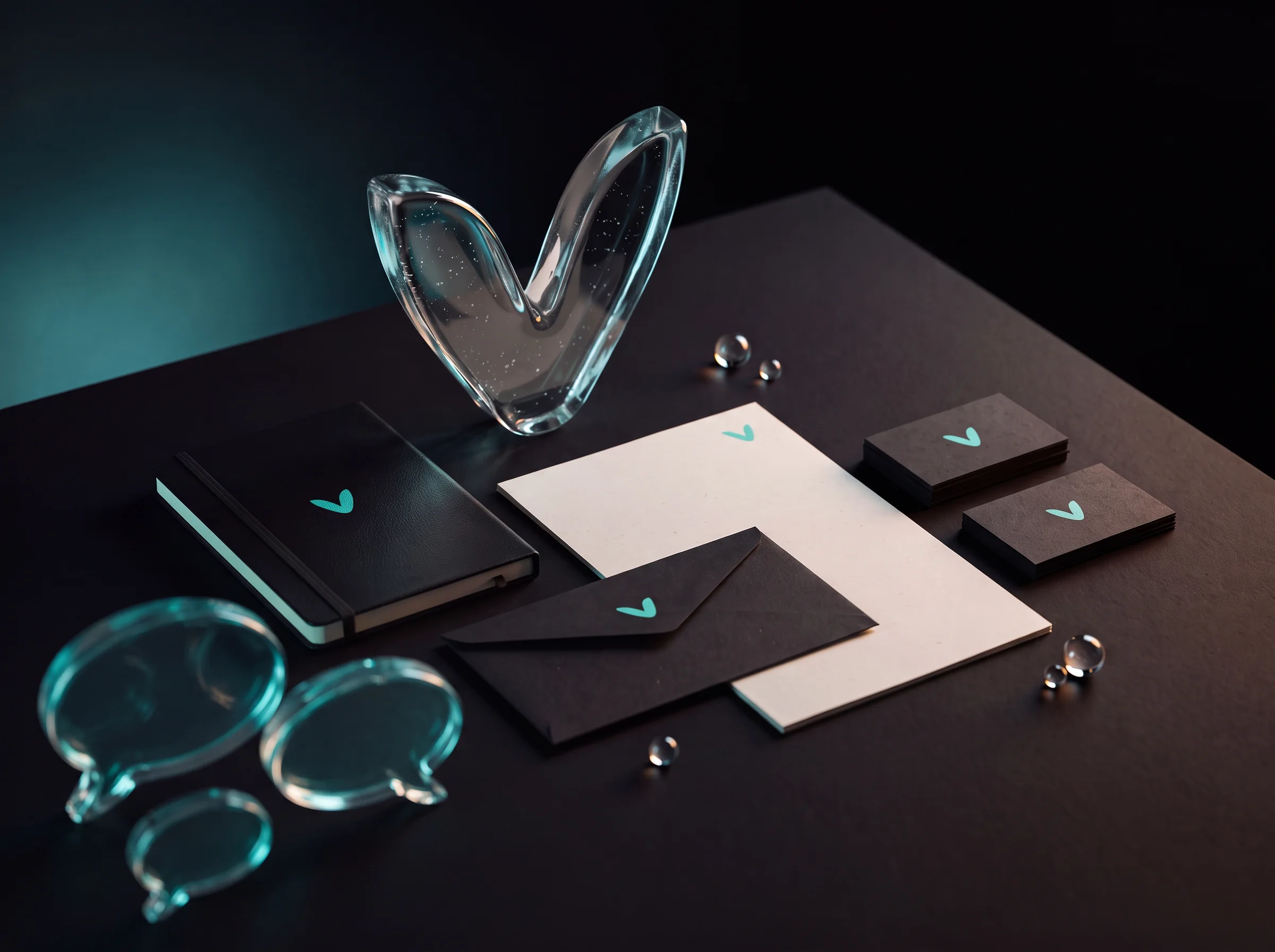 Illustration Nevalys de la création d'identité visuelle : papeterie noire et blanche (cartes de visite, enveloppes) marquée d'un V, avec objets en verre aux reflets turquoise.