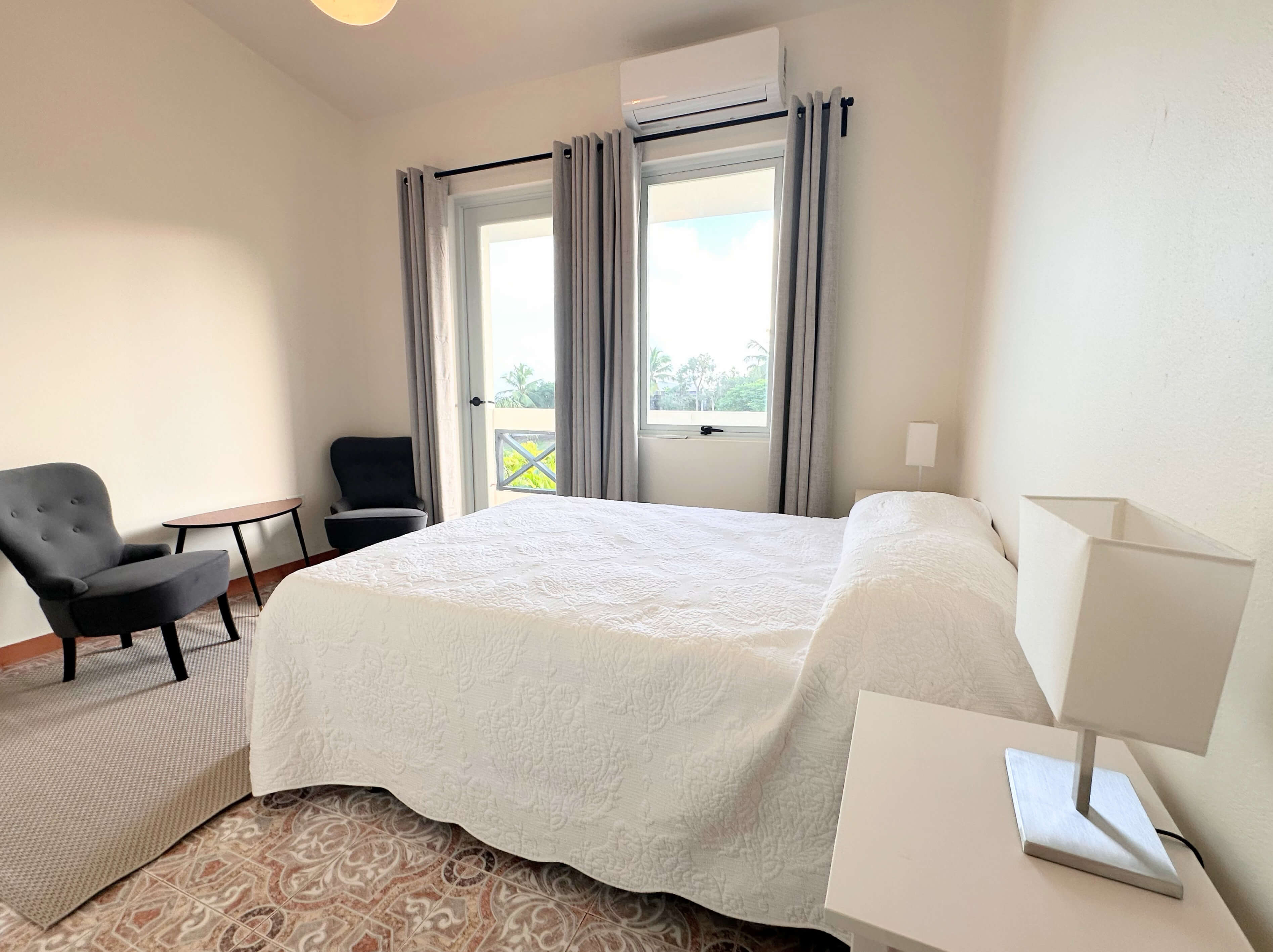 Club Vieques Room 11 with a queen bed and private balcony offering views of the tropical surroundings.