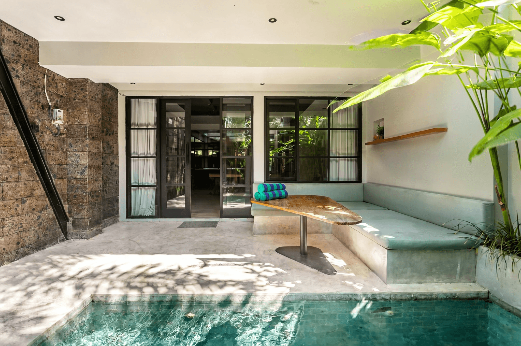 Cozy outdoor lounge area next to a private pool. Professional real estate agent services for Canggu properties.