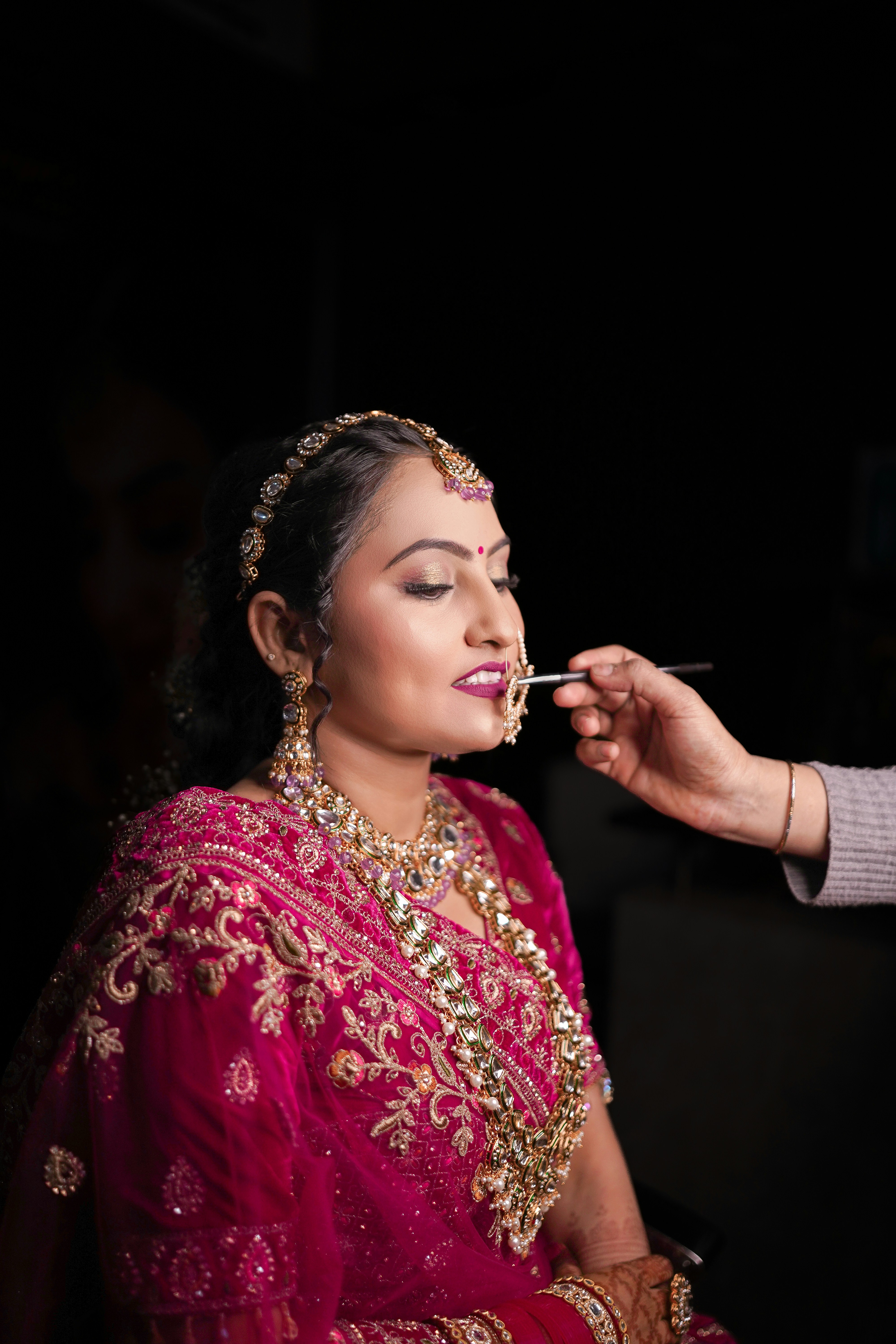 A bride is having her makeup applied.