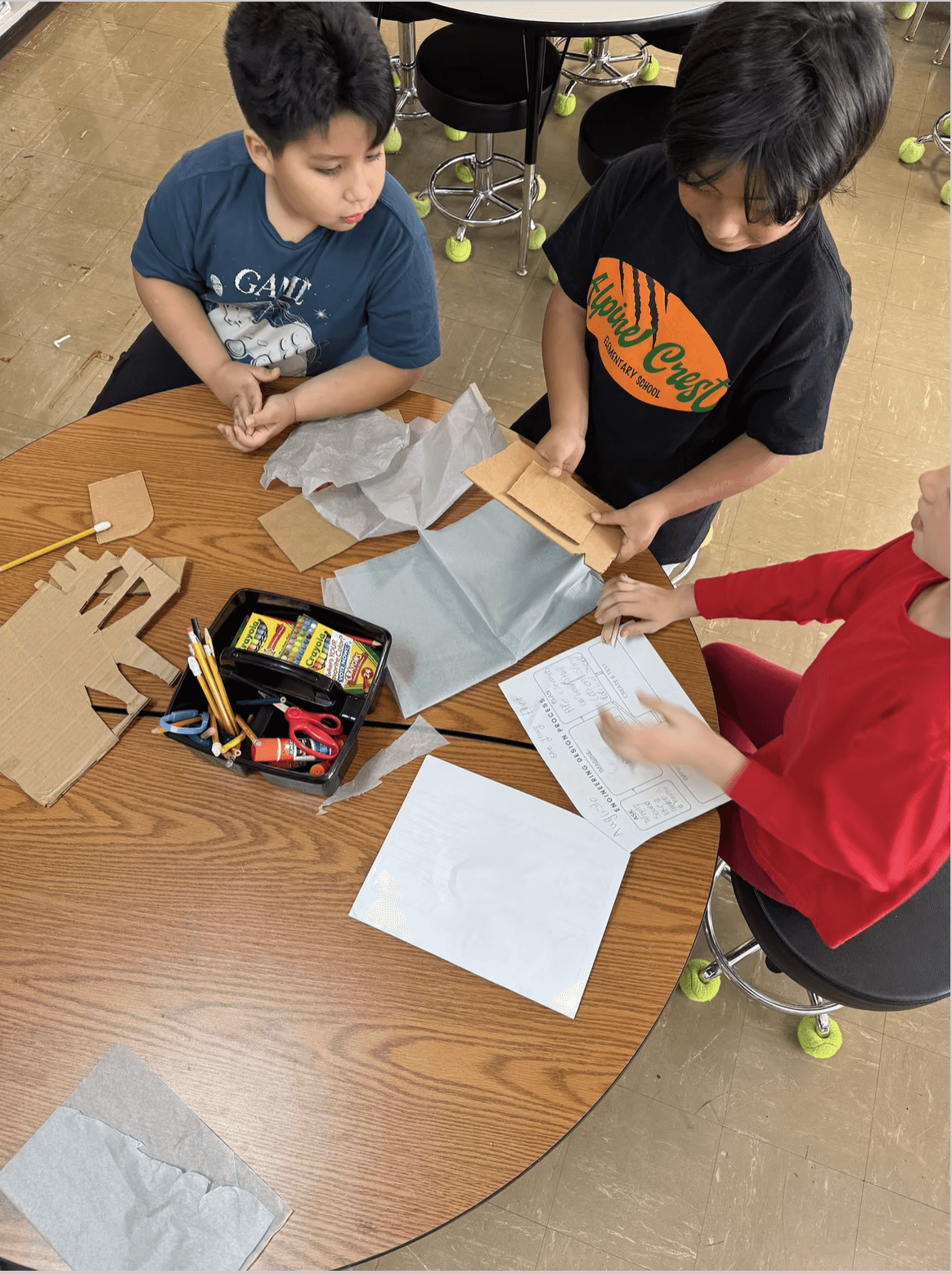 Students gathered around a table at Alpine Crest Elementary School.