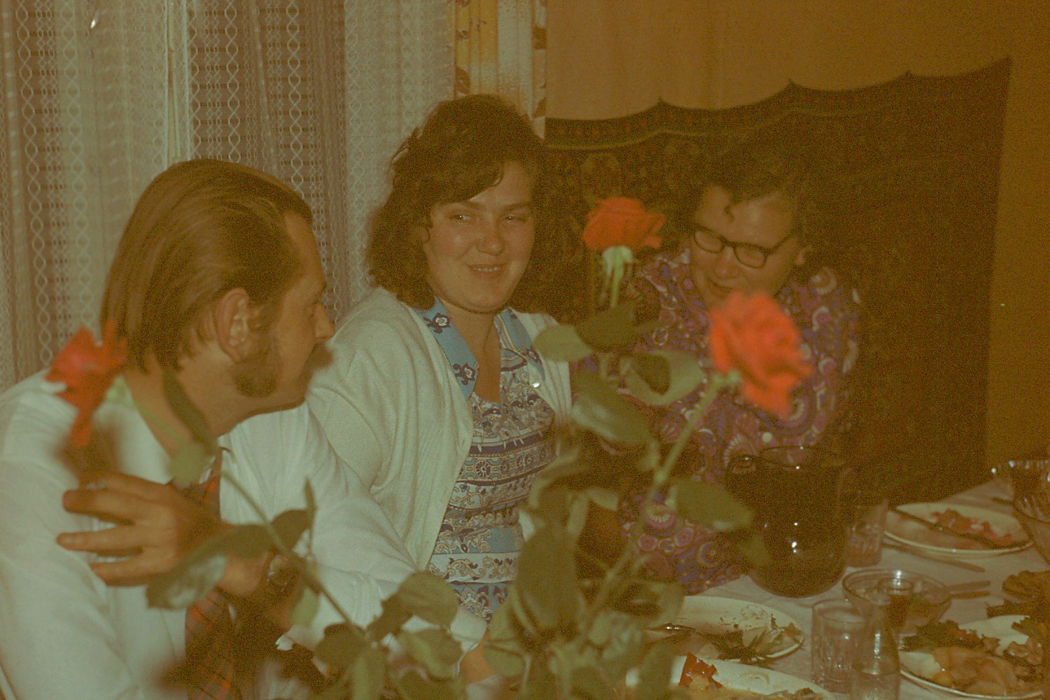 Kolm inimest istuvad toas kaetud laua ääres