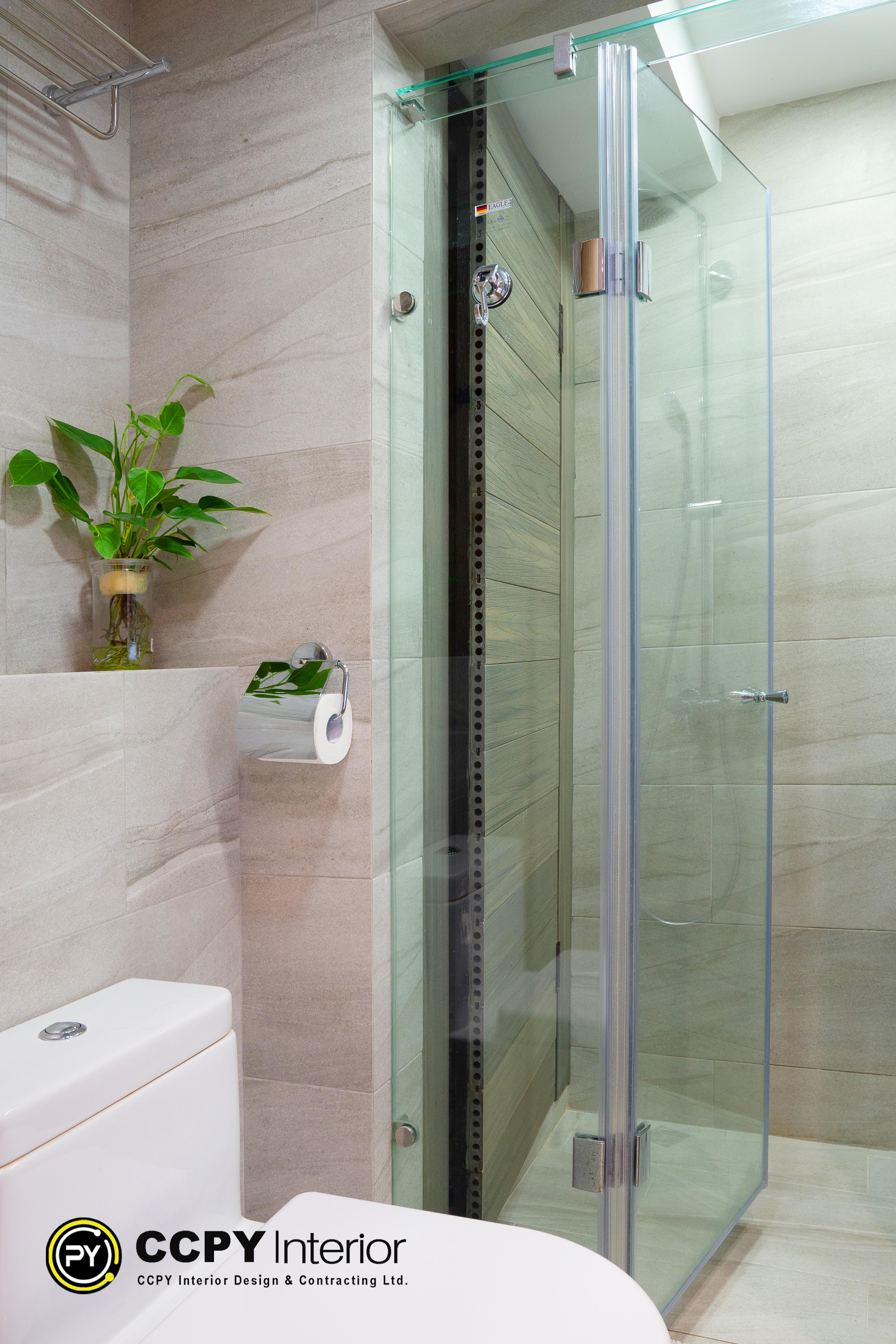 The selected region shows a modern, bright bathroom design featuring a glass-enclosed shower next to a tiled wall with a toilet paper holder.Key Visual FeaturesTiling: Light beige or off-white horizontal wall tiles paired with a contrasting wood-look accent tile strip inside the shower stall.Fixtures: A wall-mounted chrome toilet paper holder with a small built-in shelf holding a miniature potted green plant.Enclosure: A clean, frameless or minimal-frame sliding glass shower door.Lighting: Bright, natural-toned lighting that emphasizes the clean lines and neutral color palette of the compact space.