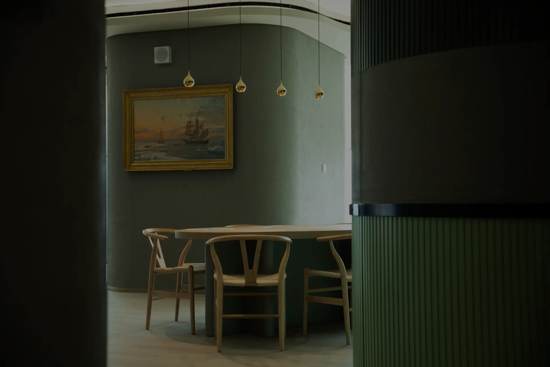 Commercial Suites meeting room in Dubai with sage-green panelled walls and brass pendants