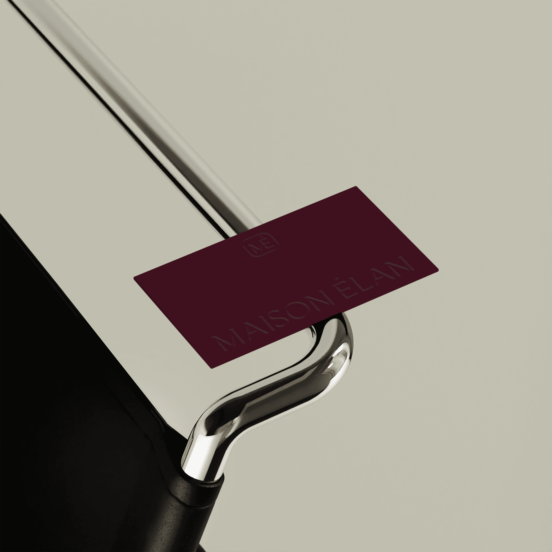 A Maison Élan business card. The card is burgandy with the brand logo embossed on it.