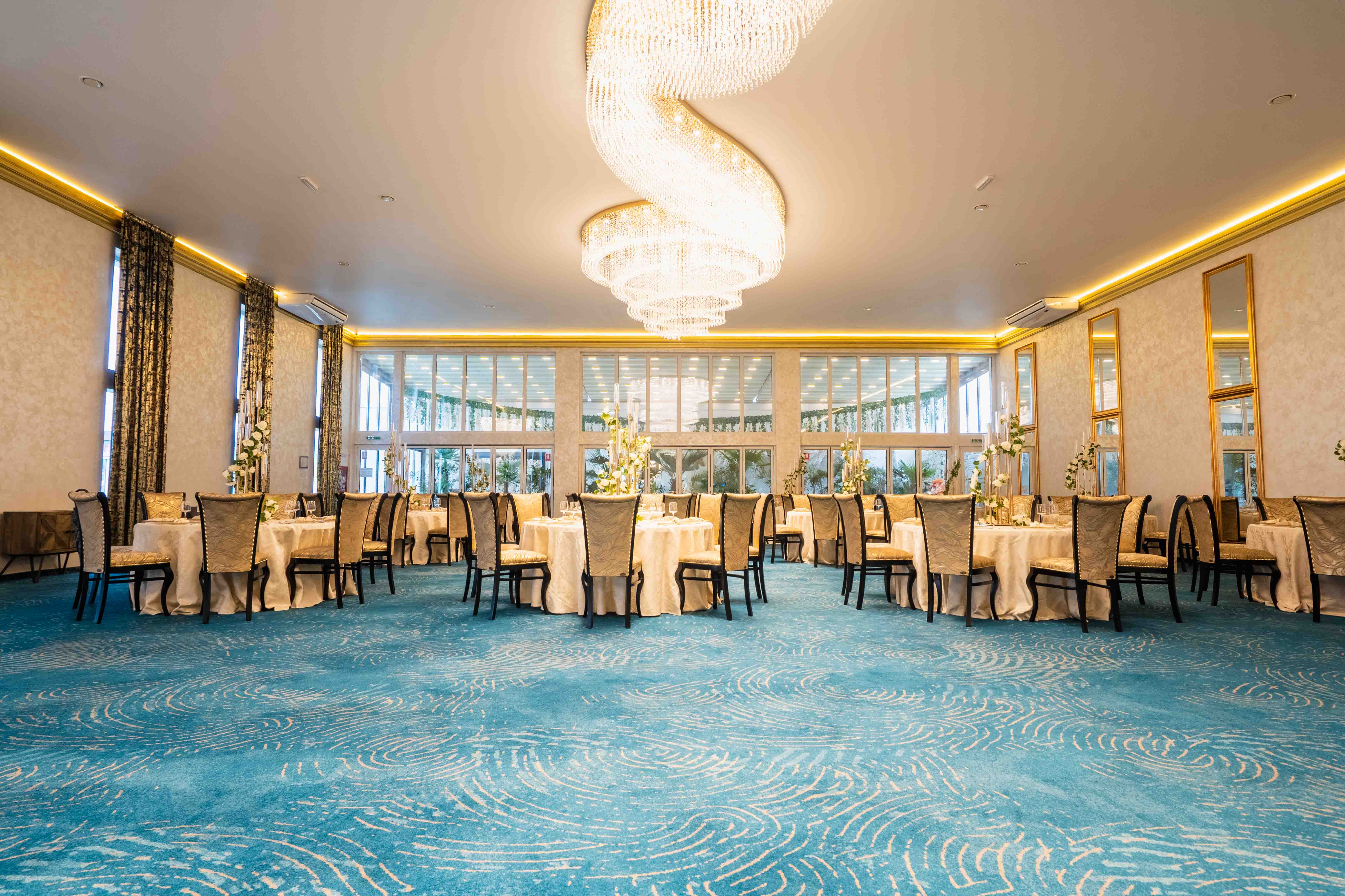 Modern bathroom featuring a walk-in shower, wooden vanity, round mirror, and elegant marble tiles.