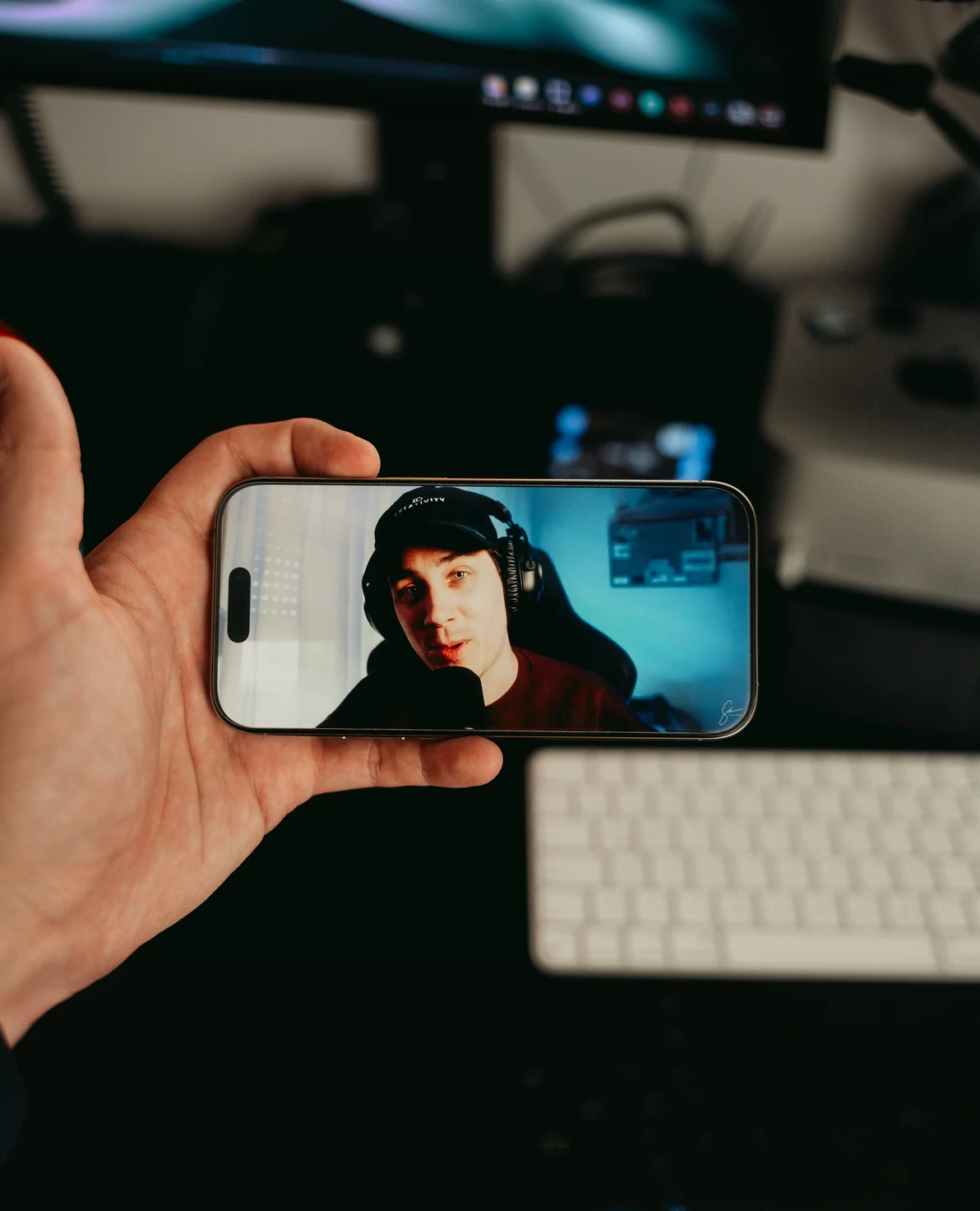 Hand holding phone displaying a live streaming creator