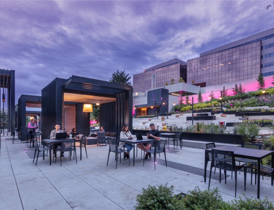 People enjoying a vibrant plaza with diverse amenities, reflecting T-Mobile's innovative and people-first culture.